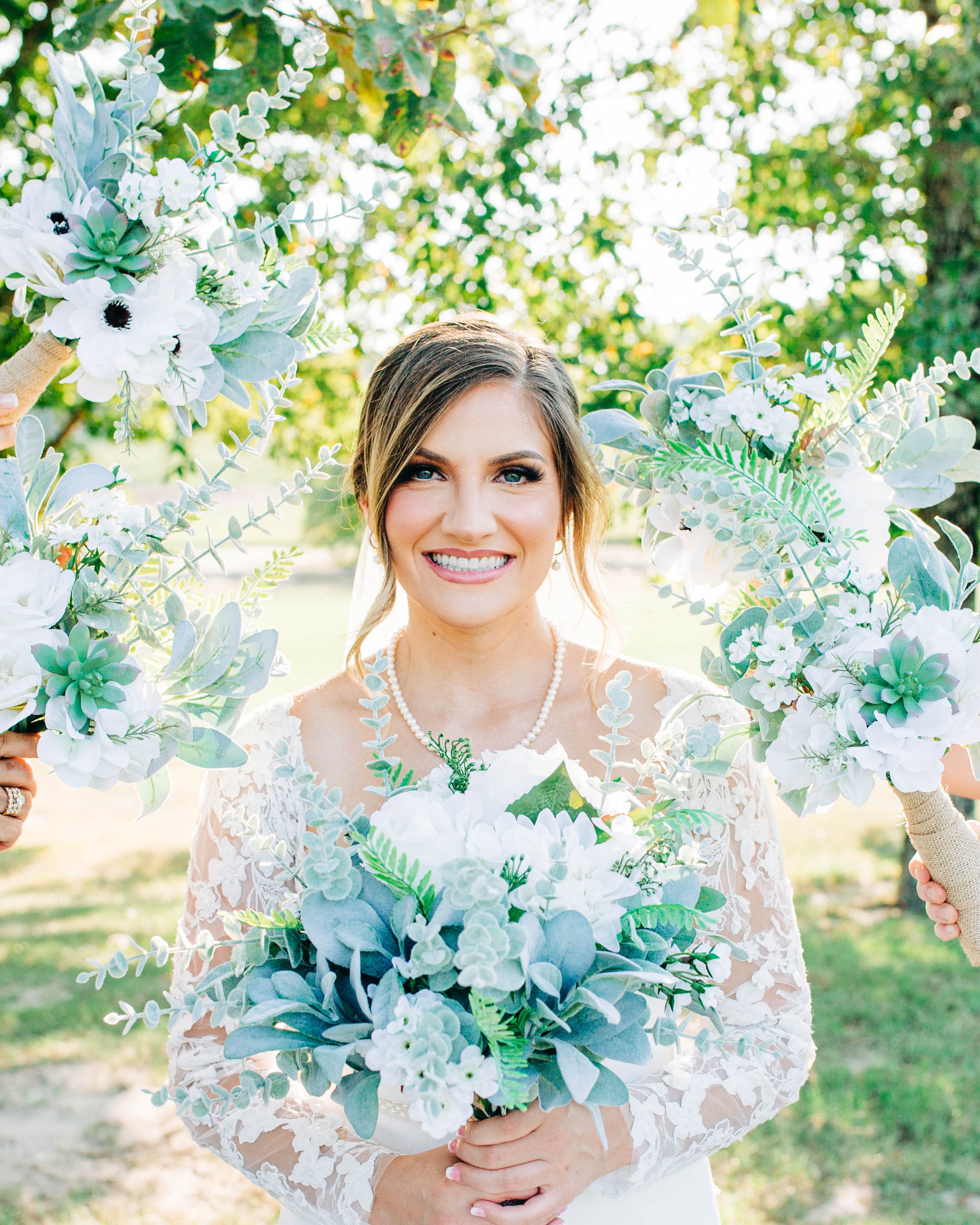bride with bridesmaids bouquets around her face dusty blue flowers.jpg