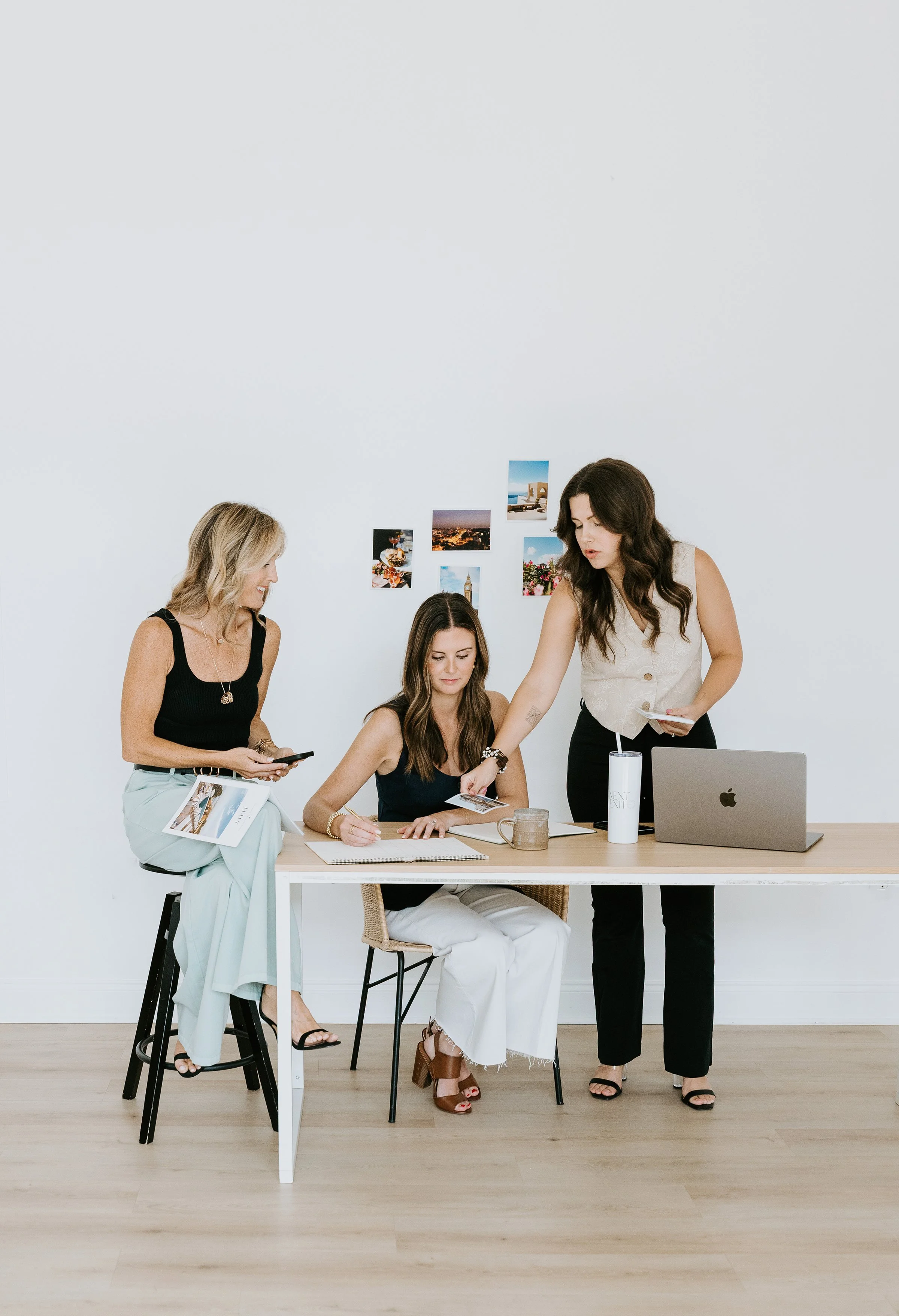 Casey, Haleigh & Natalie working at a desk planning a client trip.