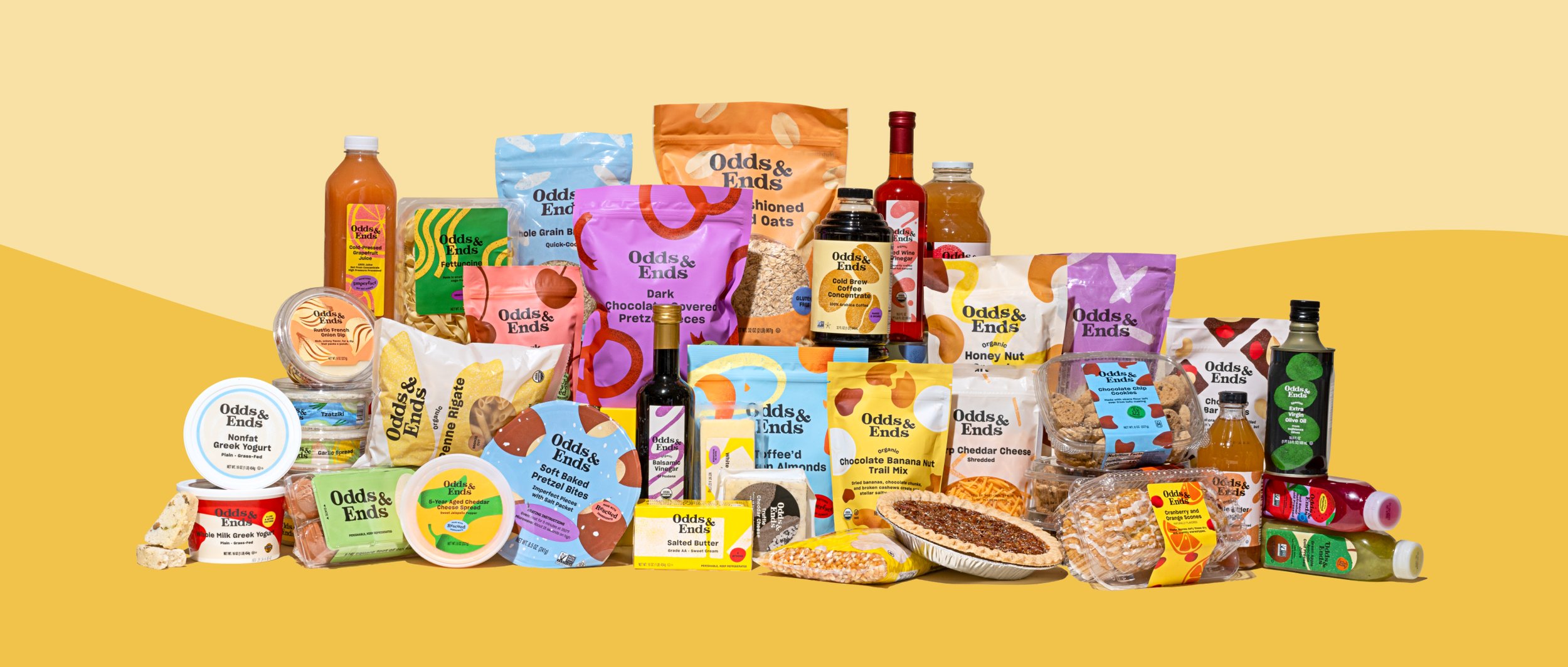A colorful assortment of packaged food products from Odds & Ends, including snacks, condiments, beverages, and baked goods, arranged on a yellow background.