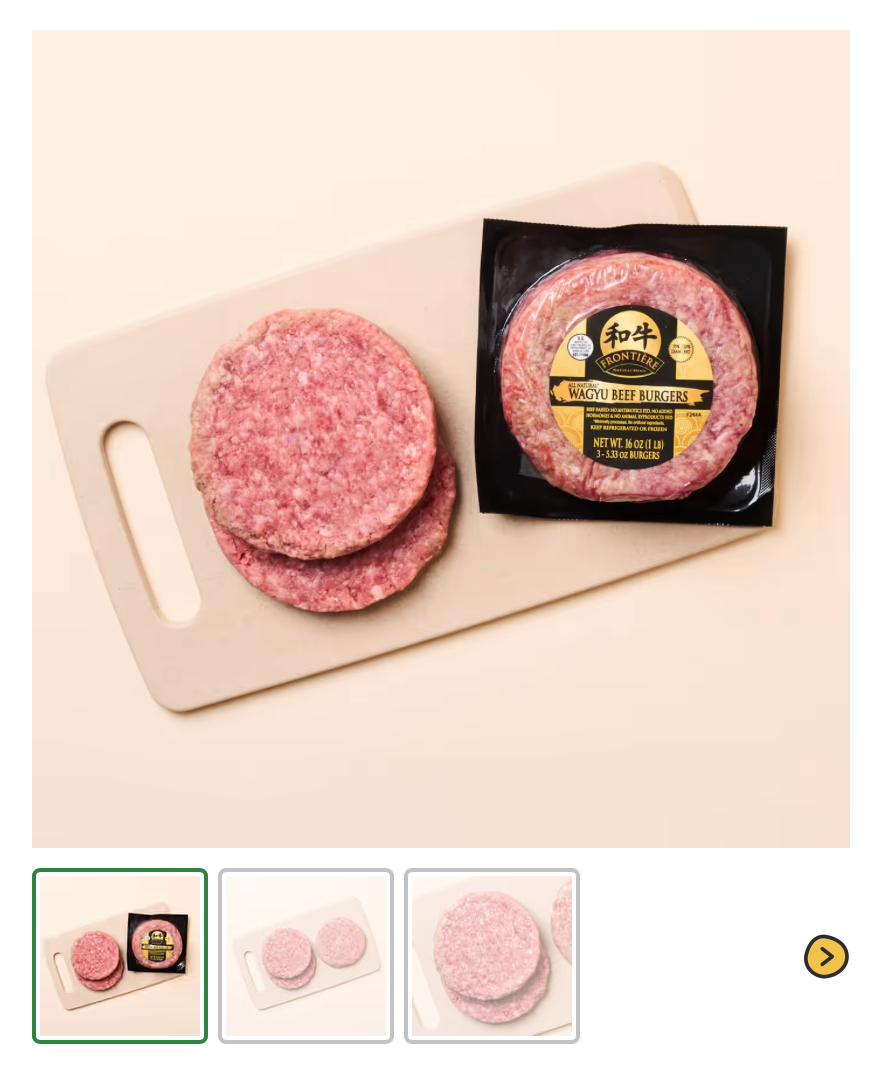 Unpackaged Wagyu beef burger patties and a packaged Wagyu beef burger patty on a white cutting board.