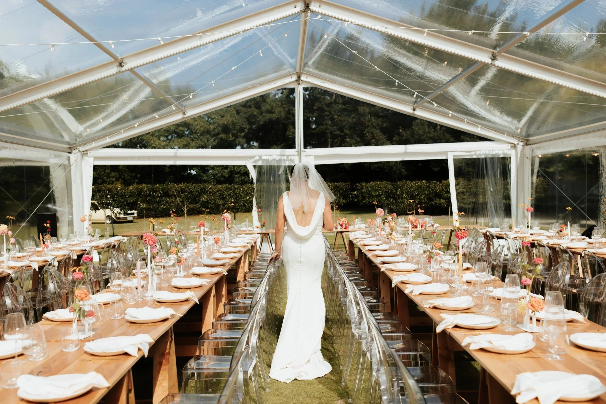 Long trestle tables set inside a Loula clear marquee