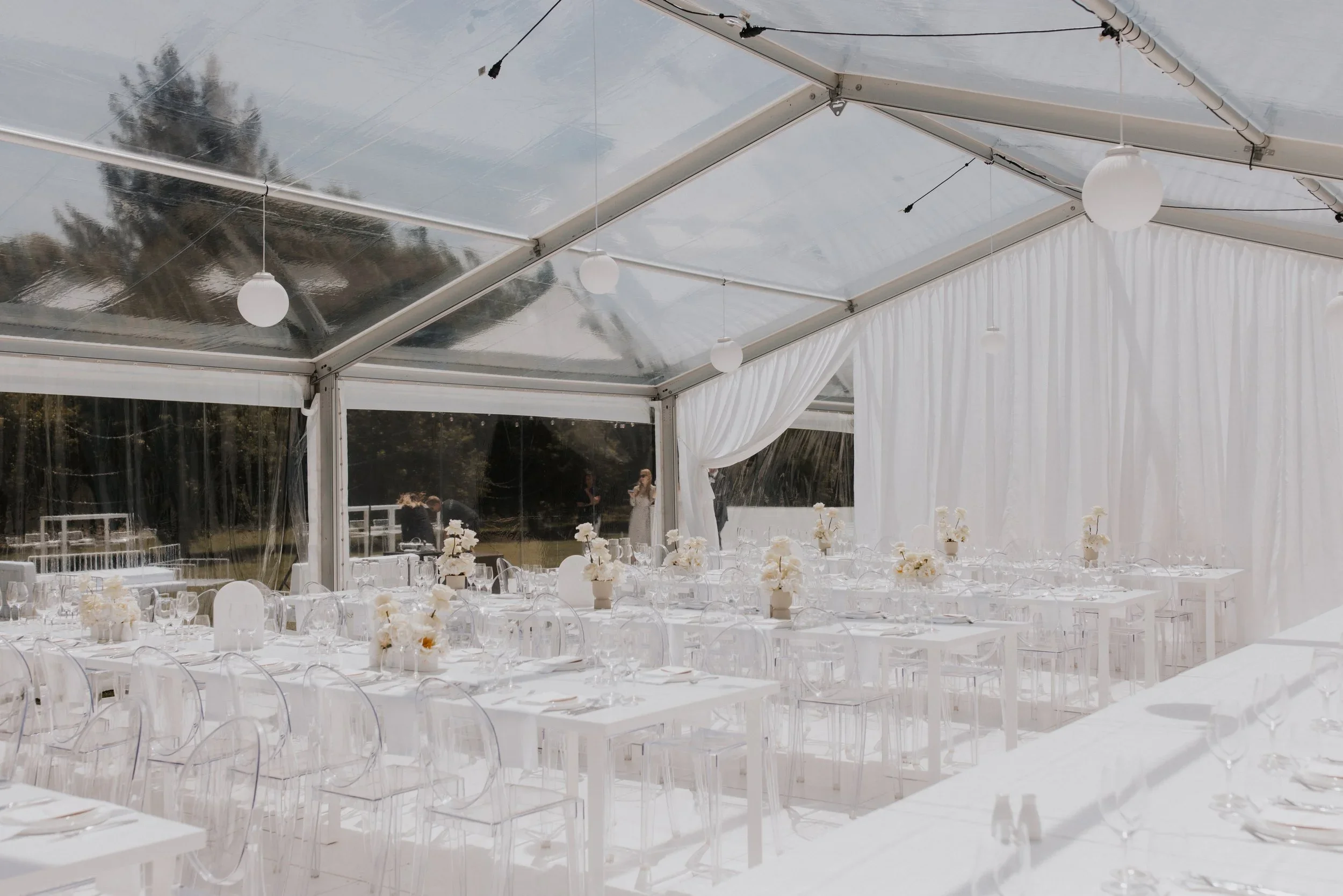 Inside the Loula clear marquee draped in white, with views to the trees