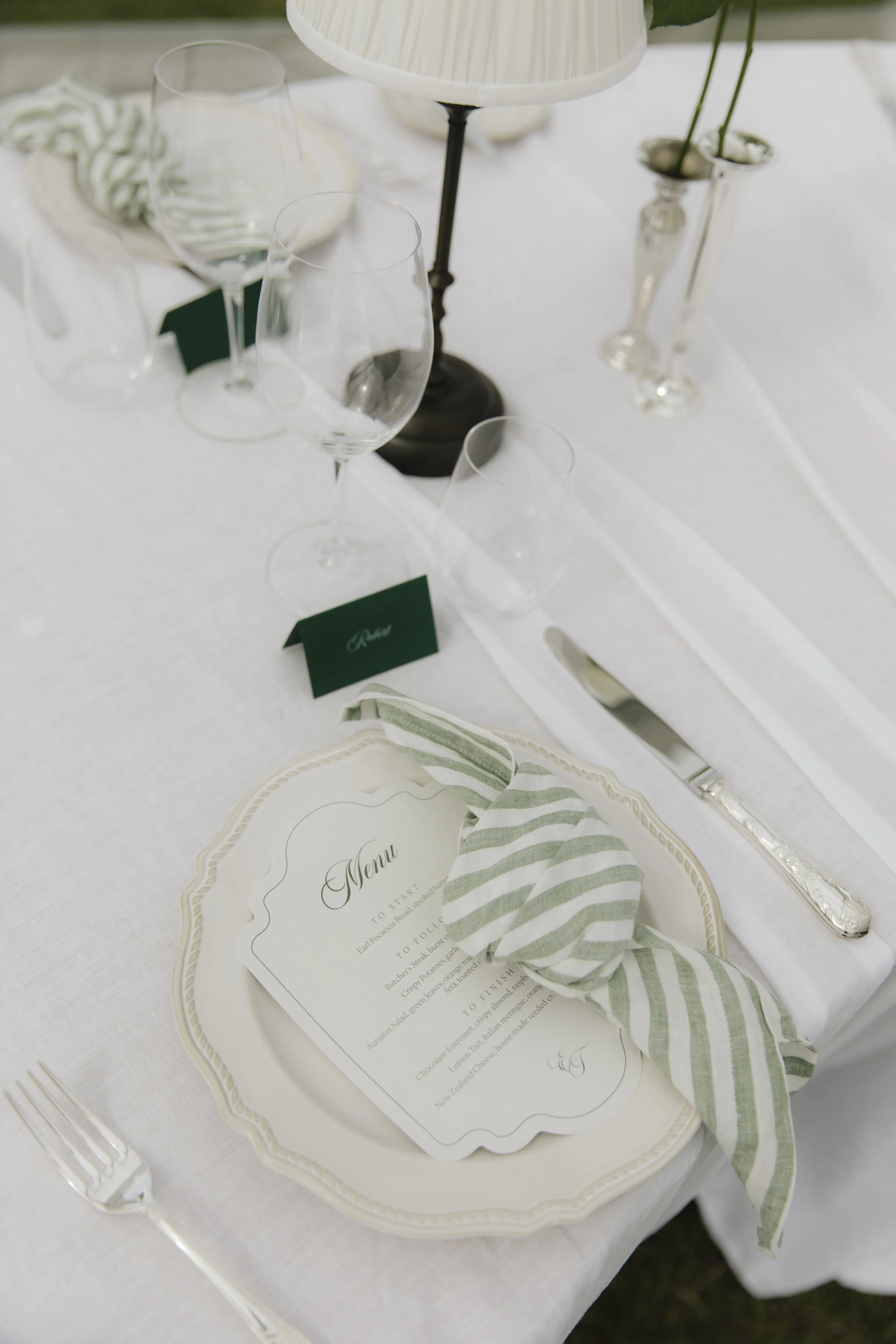 Table setting with a green napkin at Emma & Tom's wedding at Manawa Retreat, Whitecliffs