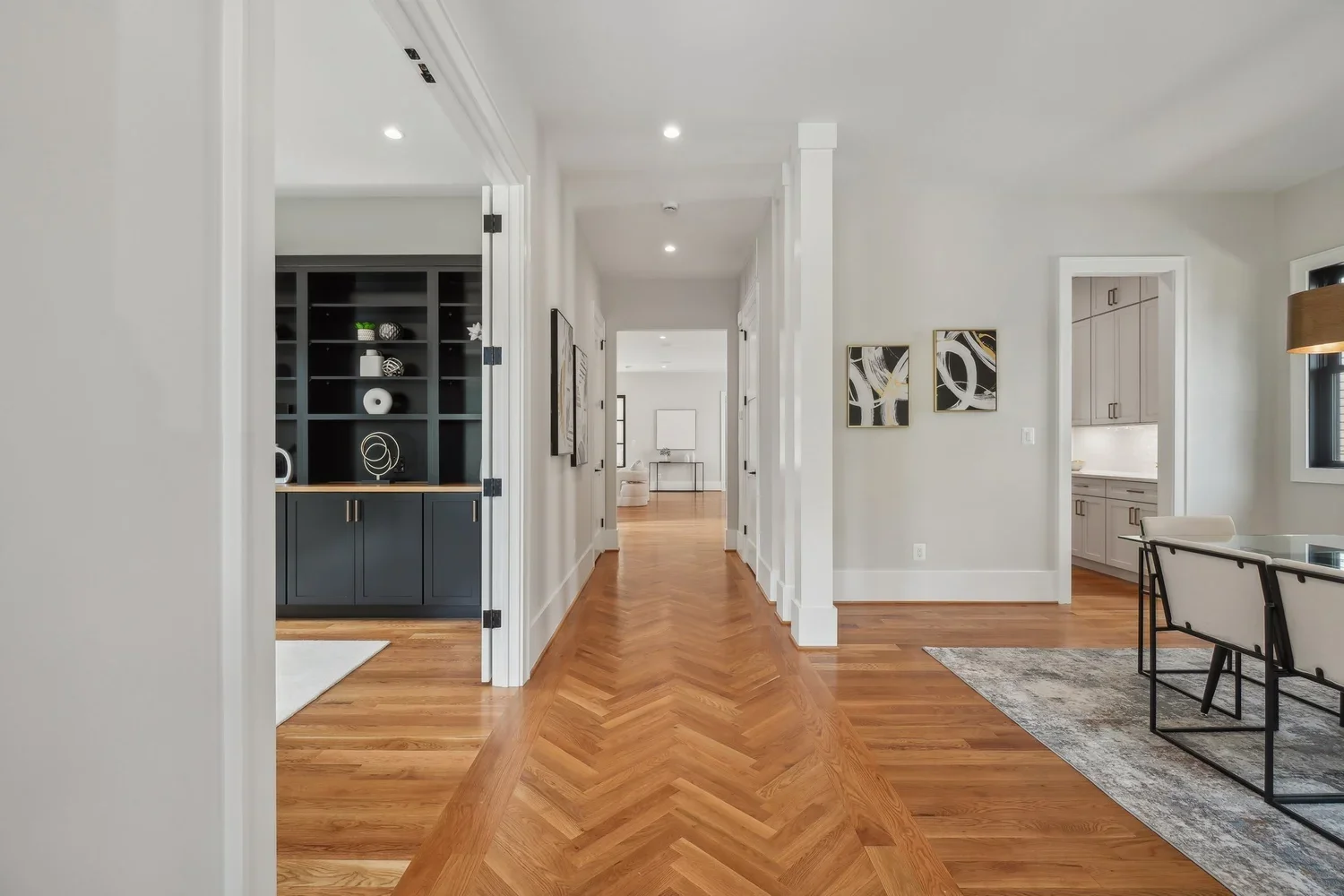 Hallway with herringbone hardwood floor, built-in cabinetry, and gallery wall in Arlington, VA