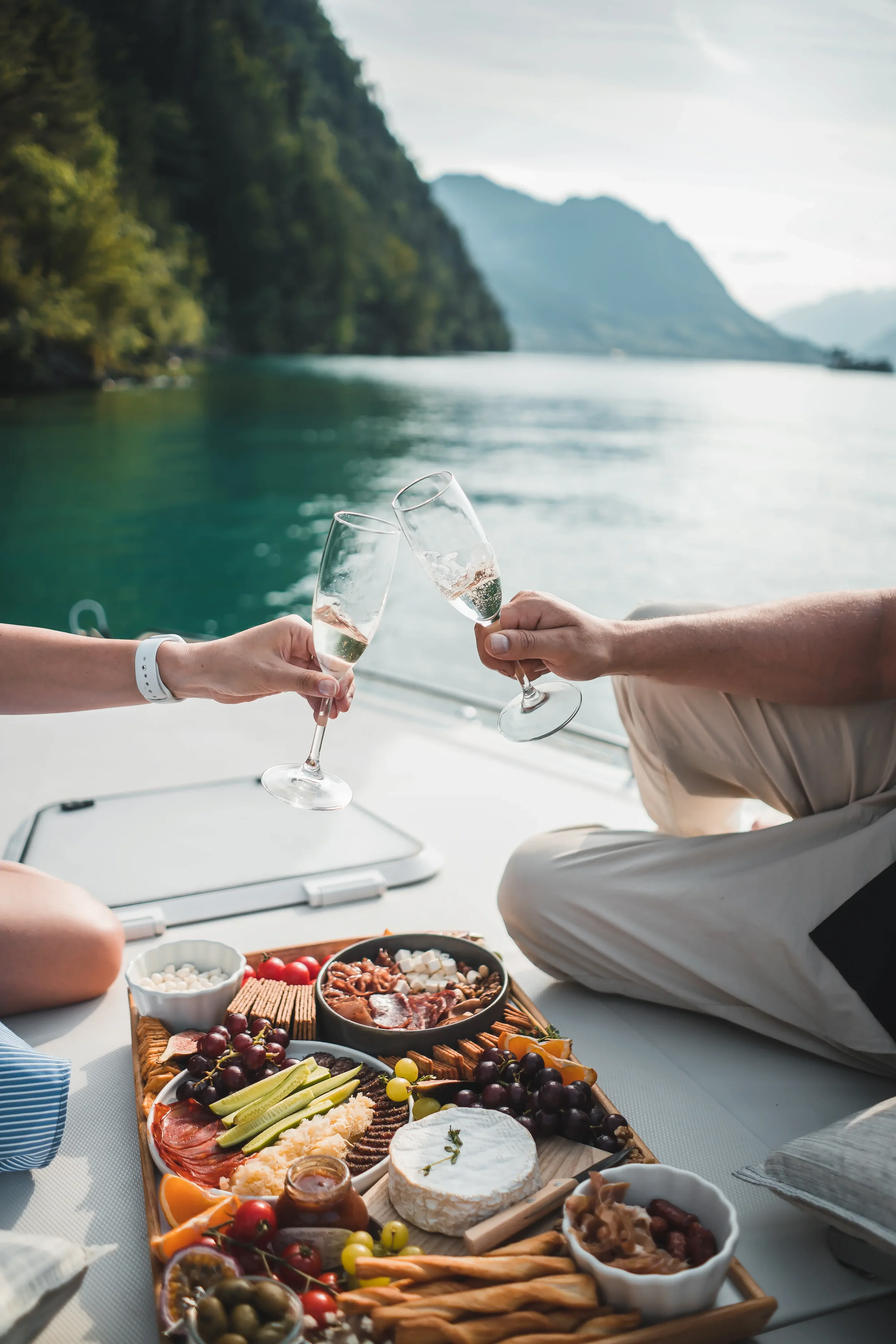 A couple share a platter together on a sail boat, celebrating wealth management done right