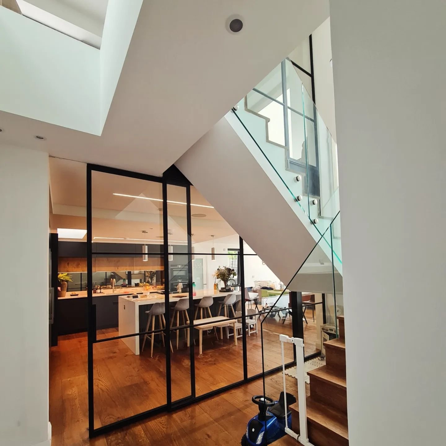 This incredibly unique project features a two-story steel-framed glass partition that stretches from the ground floor to the first floor ceiling, complete with a sleek flysh ceiling slider door that opens into the kitchen. Absolutely stunning!

#slid
