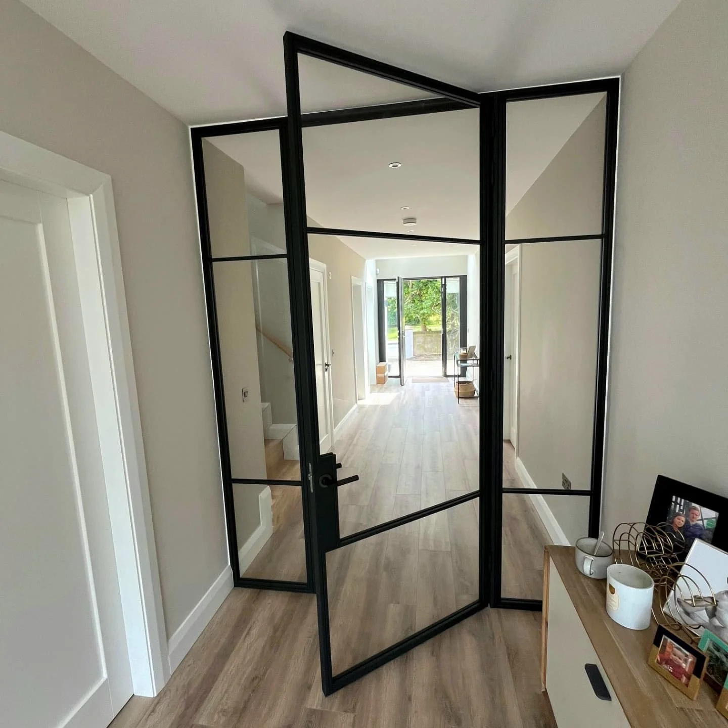 Stunning entryway! - This beautiful feature door welcomes you into the heart of the home.
After exploring a few options, our client chose this clean, no-fuss design with uninterrupted views throughout the space.
Finished in Grey Black with Matte Br