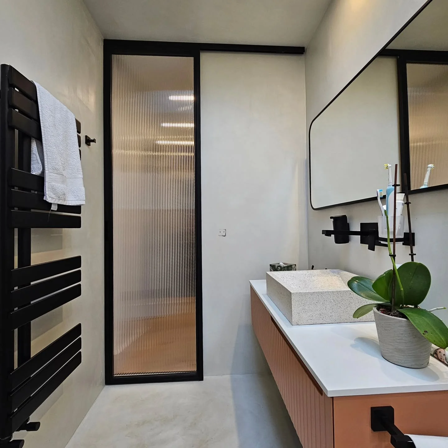 Ensuite sliding door, retro-fitted to contain steamy shower air within the bathroom. With space constraints ruling out a swing door, a slider was the only solution. Finisbed with fluted glass for added privacy and flush handles Intergrated into the d