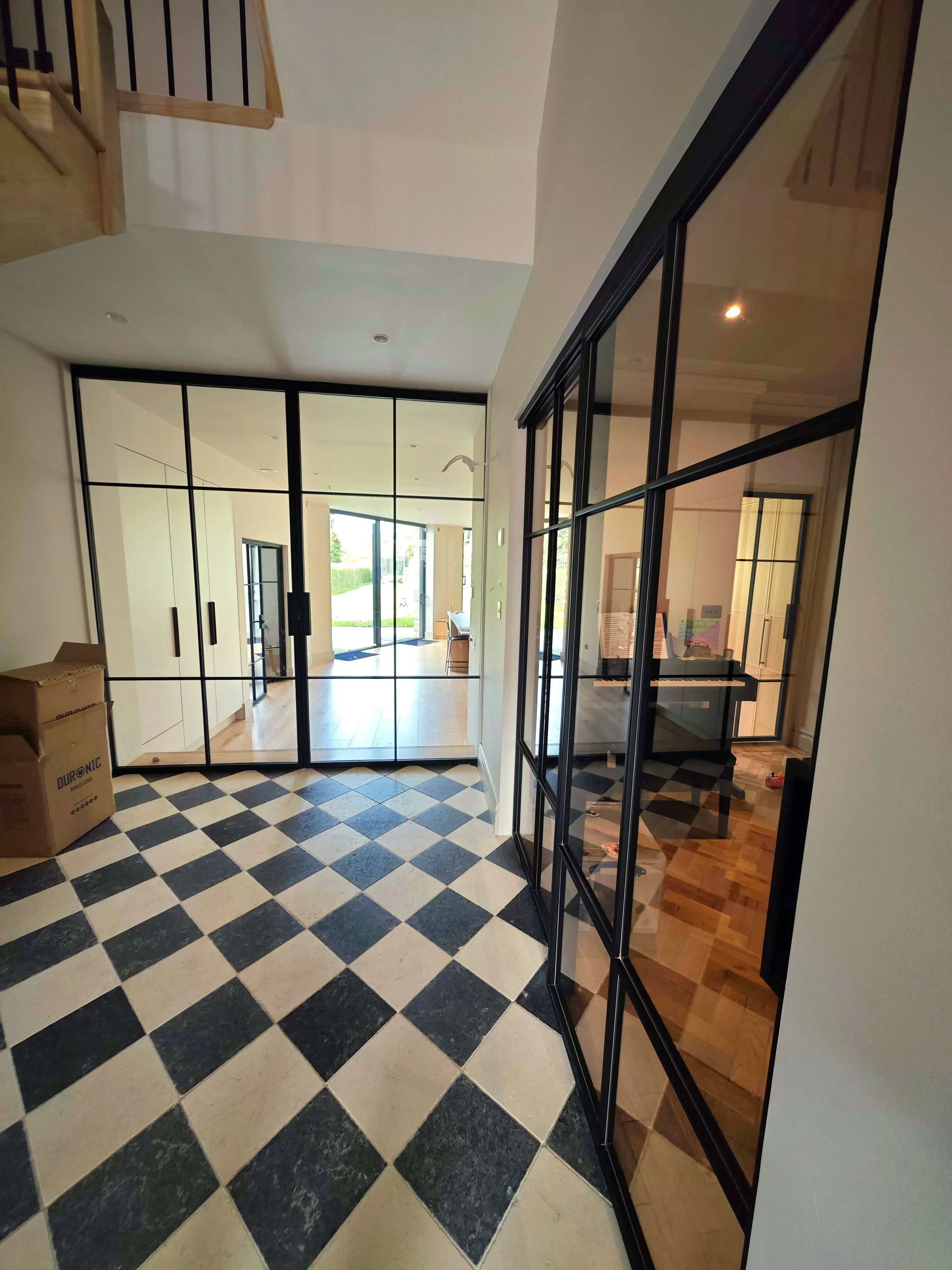 Internal steel glass sliding doors and partitions providing separation while maintaining light flow in a modern residential interior. Installed in Dublin
