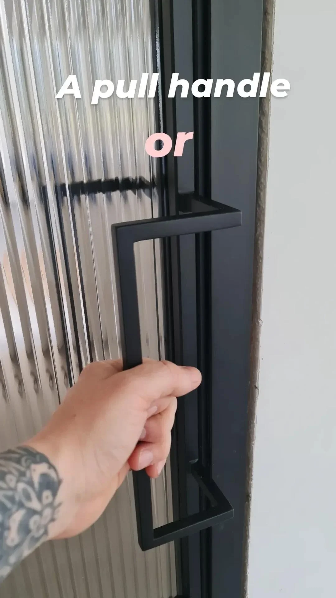 A person is pulling or pushing a black rectangular handle on a metallic door that has vertical ridges. There is a text overlay that says 'A pull handle or'.
