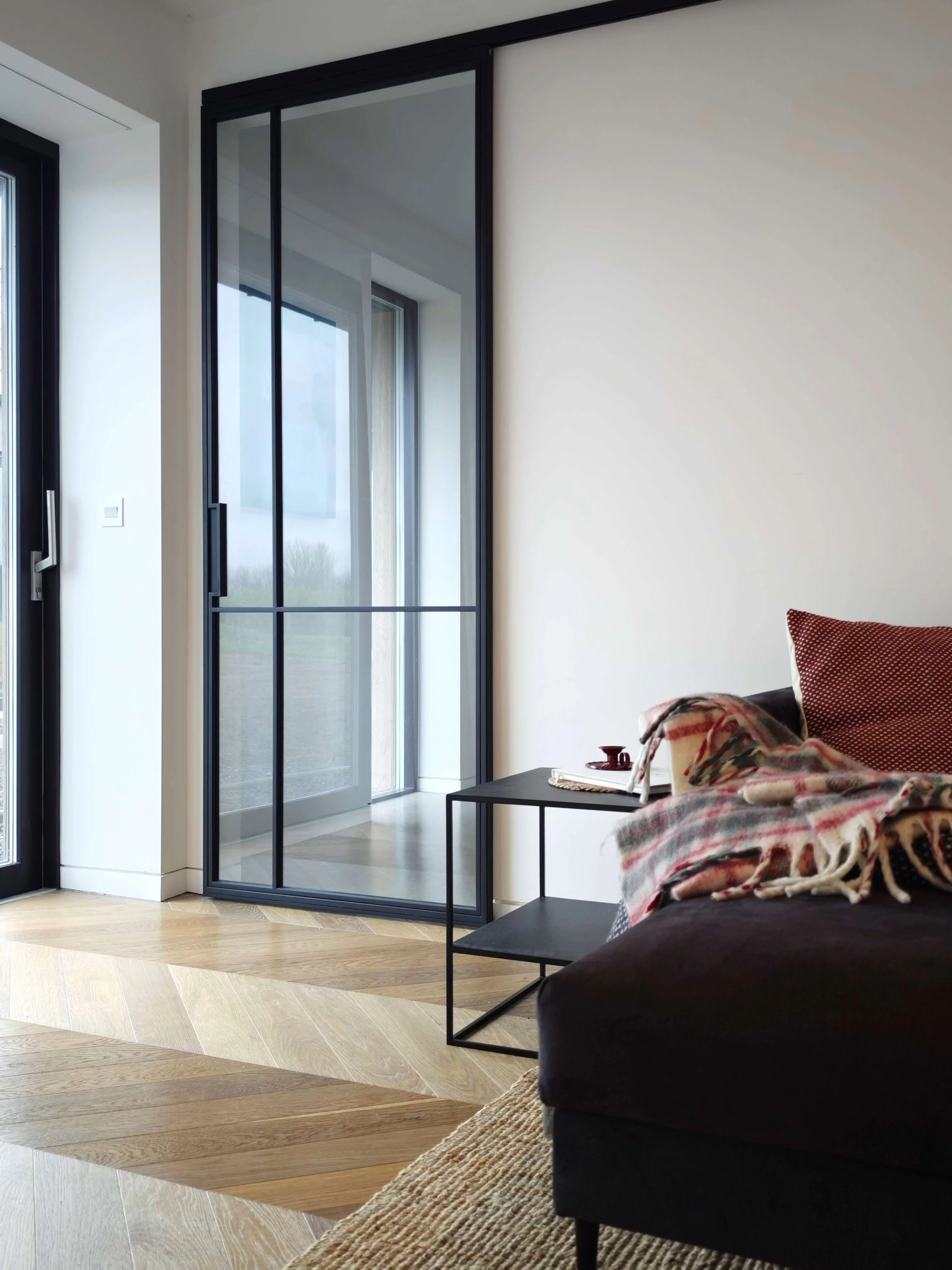 Sitting room corner with black frame glass sliding door in the closed position