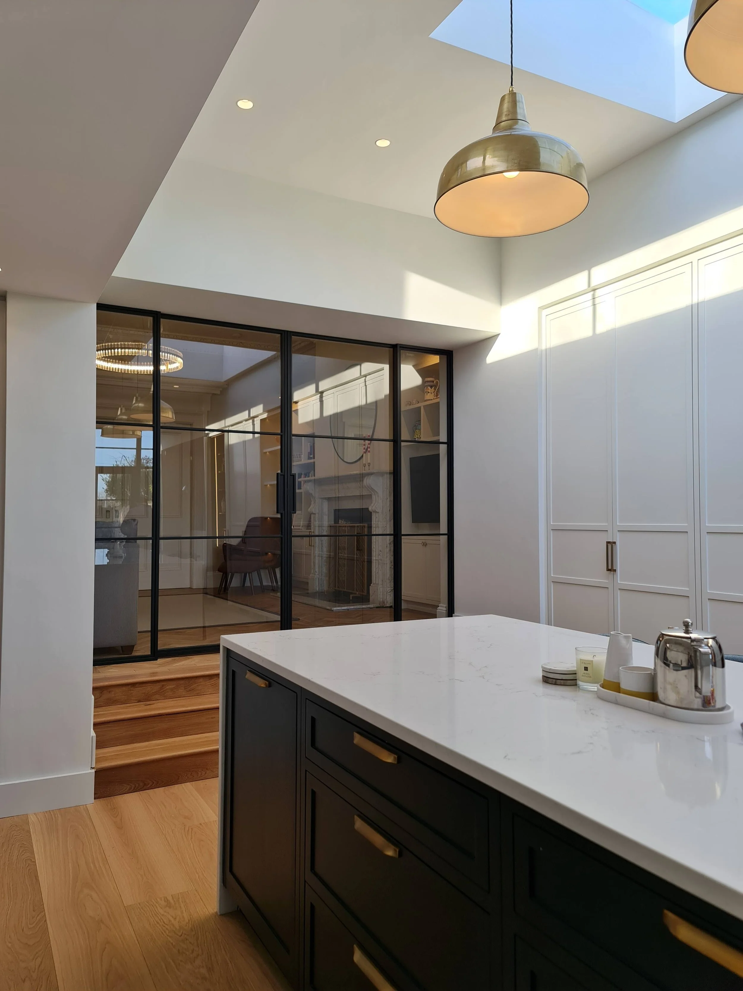 Modern kitchen with marble counter tops steps leading to steel frame double sliding doors