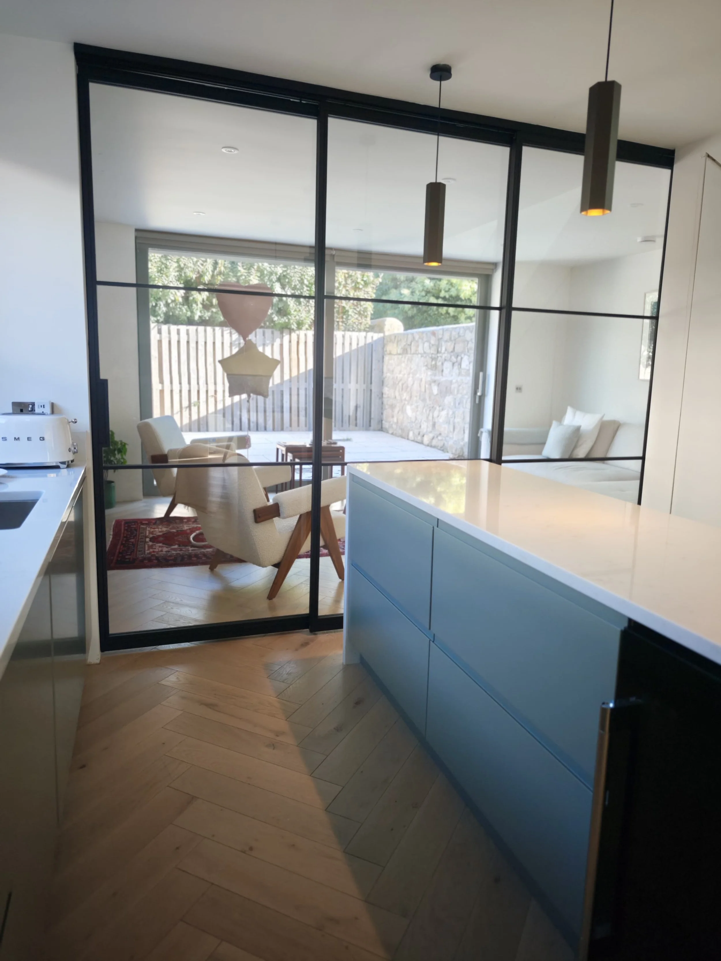 Kitchen and sitting area separated by glass sliding stacking doors