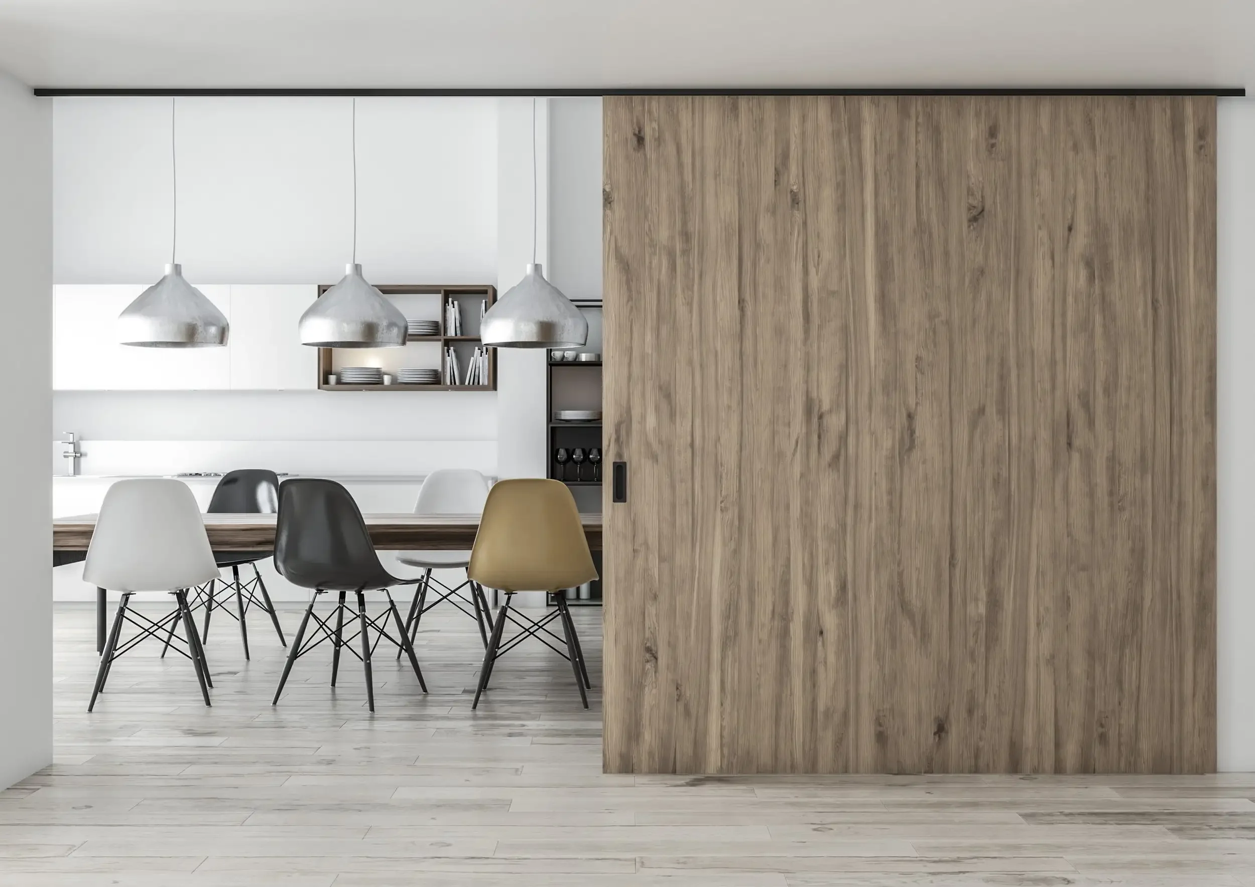Modern dining area with a sliding wooden door, pendant lights, and mismatched chairs around a table on light wood floors.