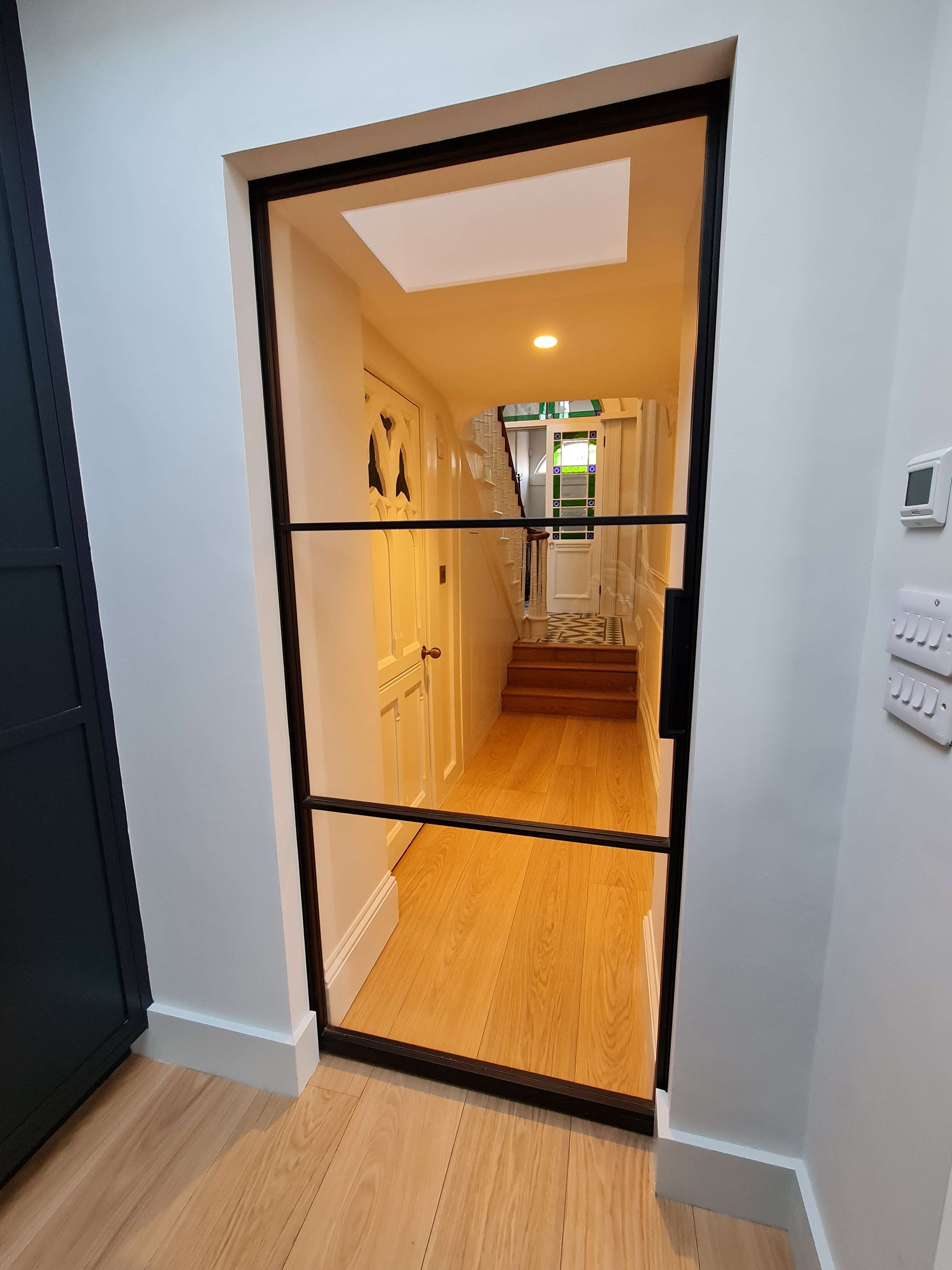 Kitchen and hallway separated by a glass sliding pocket door