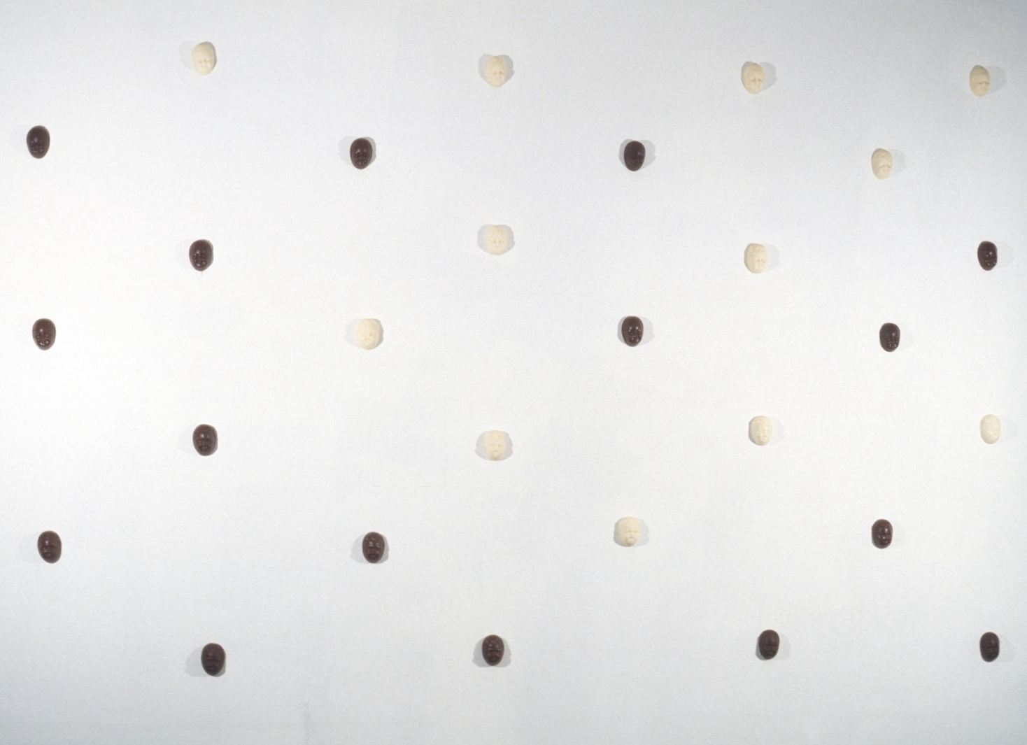 Changing Demographics (1994). Chocolate, beeswax, dark and white chocolate cast heads, installation varies. 3.5 x 2.5 x 1" ea. 