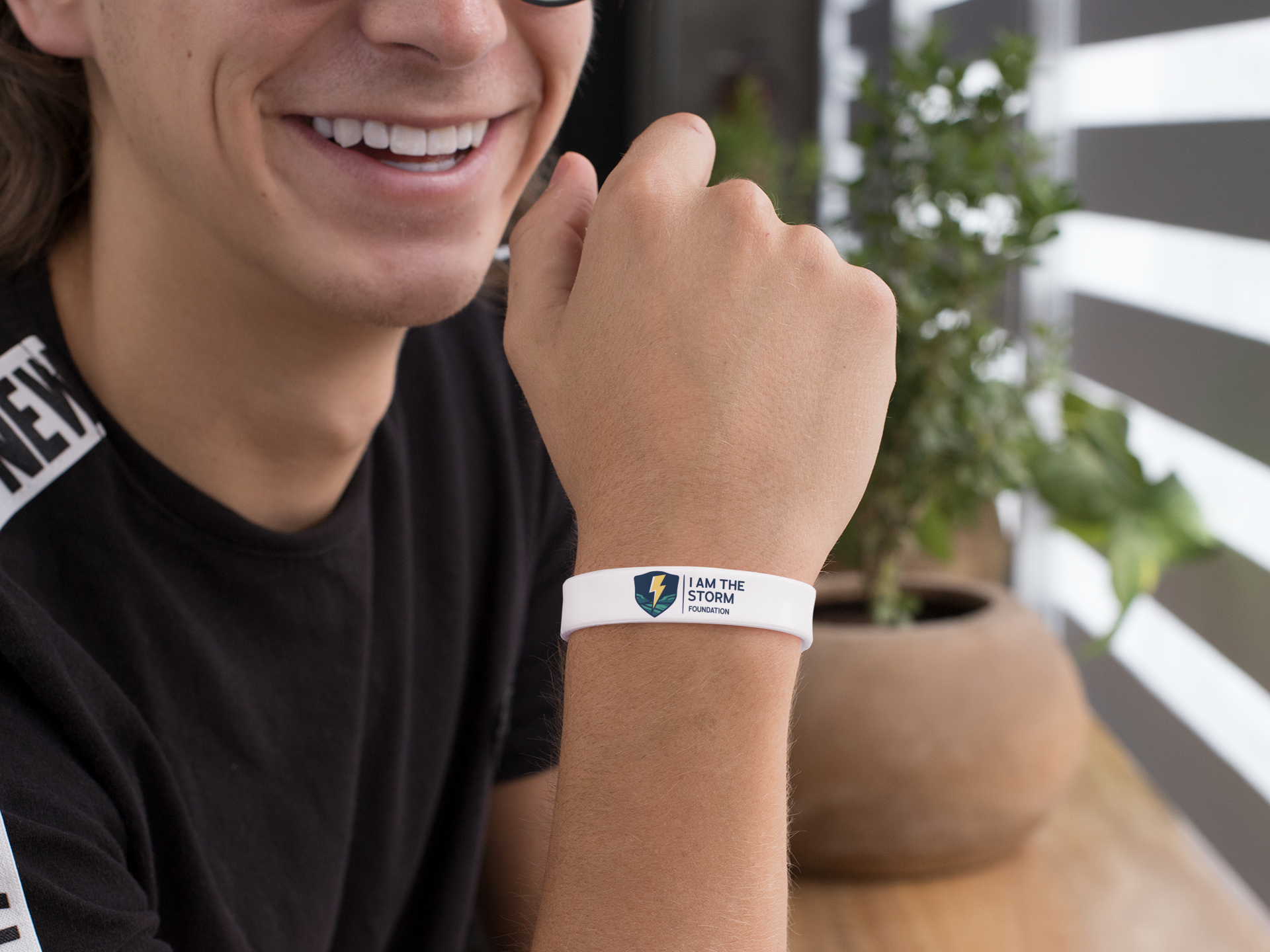 silicone-wristband-mockup-featuring-a-smiling-guy-by-a-plant-pot-28244.png