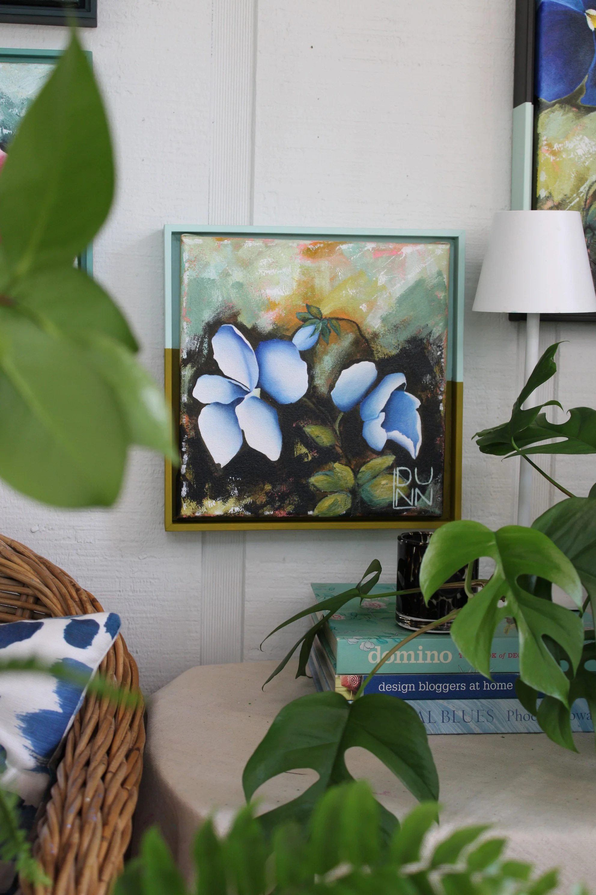 Shop Pansy IX by Laura Dunn, a 10 x 10 original blue and white pansy painting in acrylic and charcoal on canvas, with green foliage and golden tones.