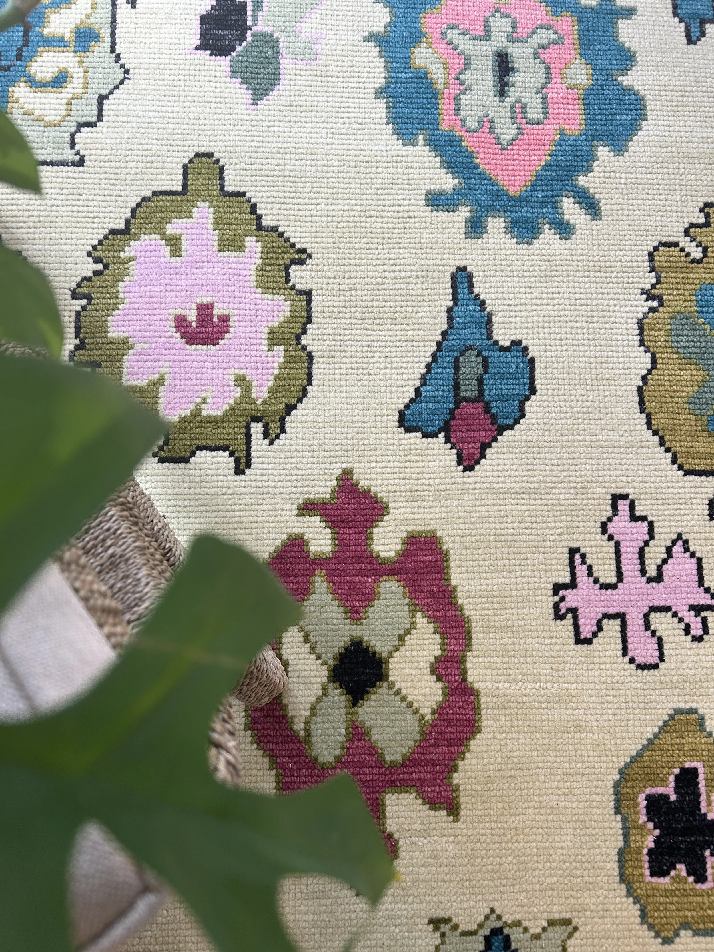 detail of colorful traditional oushak rug with plant