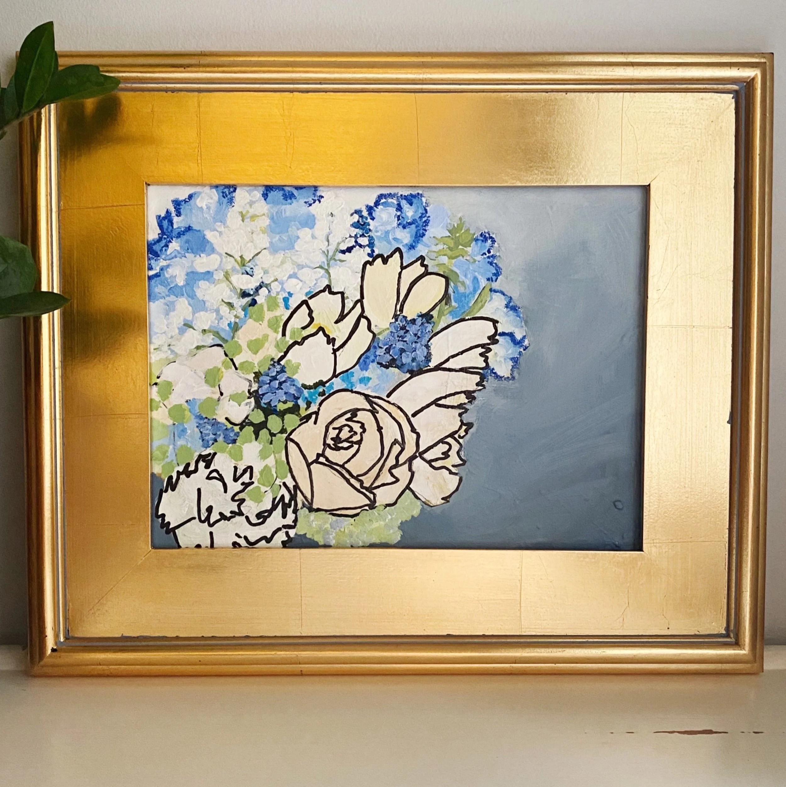 A framed painting of a floral bouquet with blue, white, and green colors, with some parts in black outline, set against a gold-colored frame.