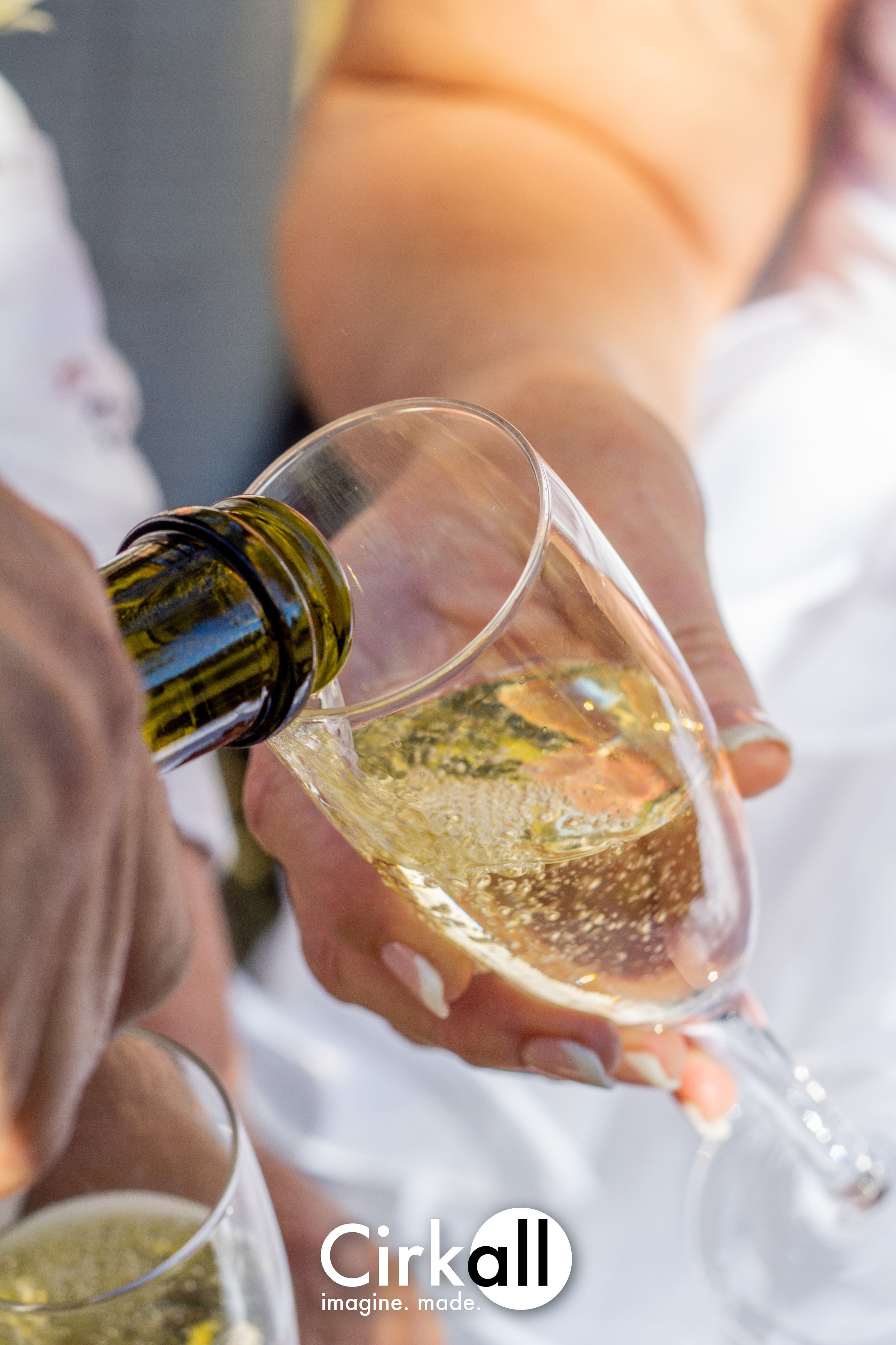 Person pouring champagne into a glass at a celebration or event.