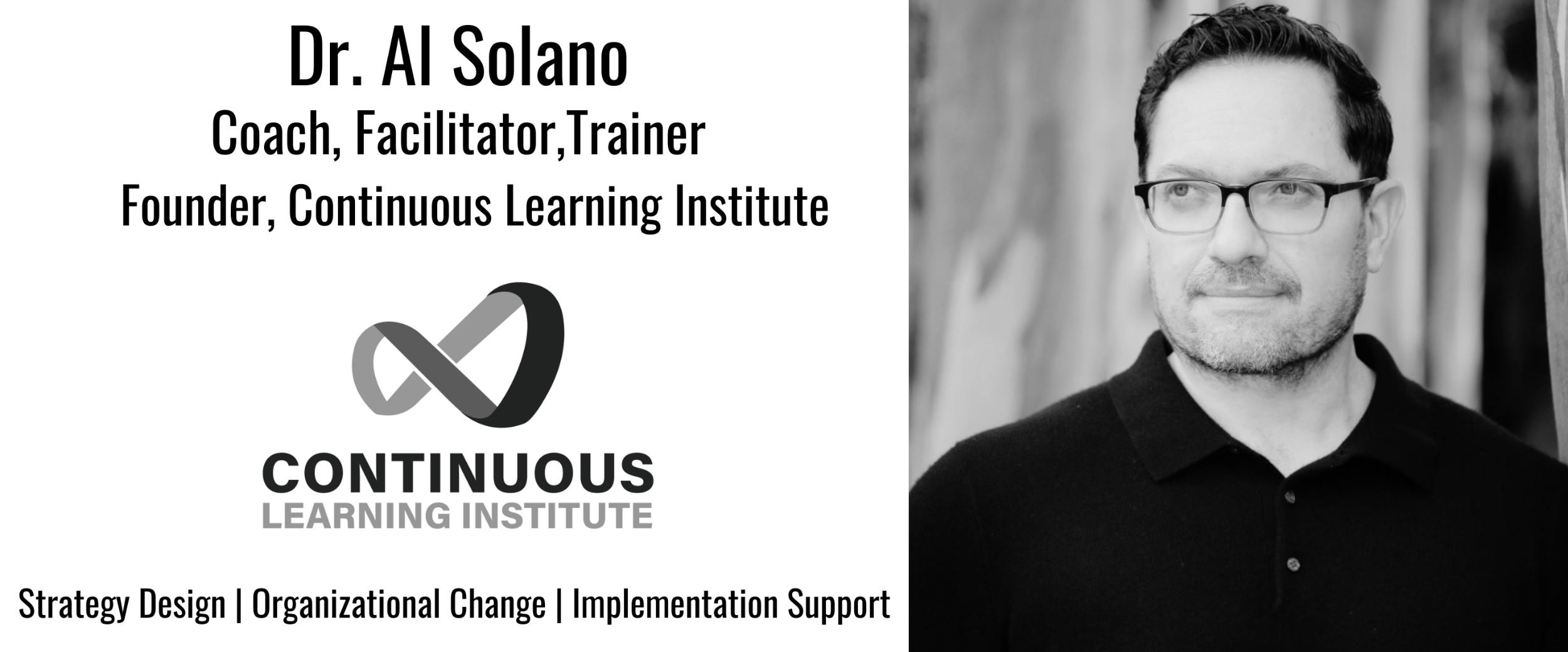 A man with short hair wearing glasses and a black shirt staring off to the side with a neutral background