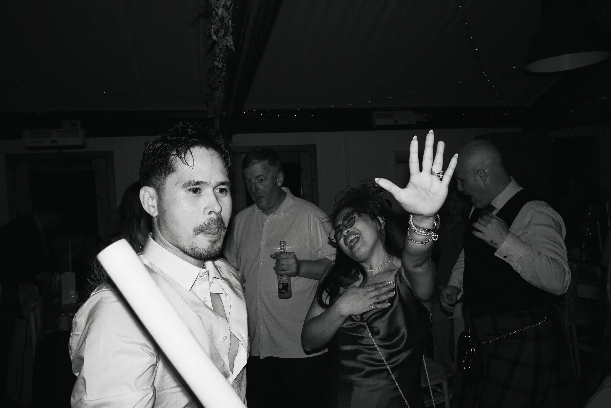 People dancing and socializing at a party or celebration in an indoor venue.