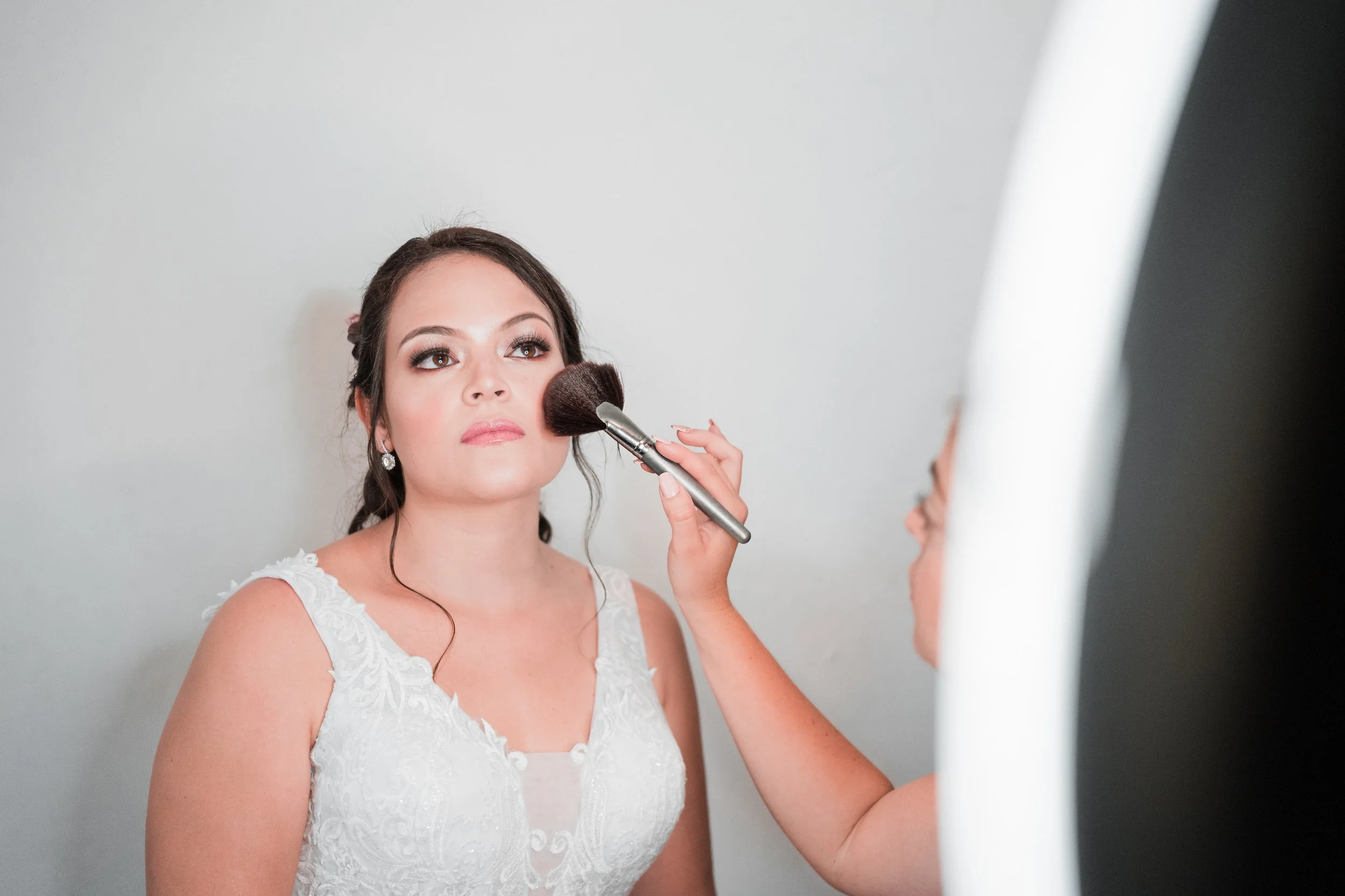 woman getting makeup done on wedding day