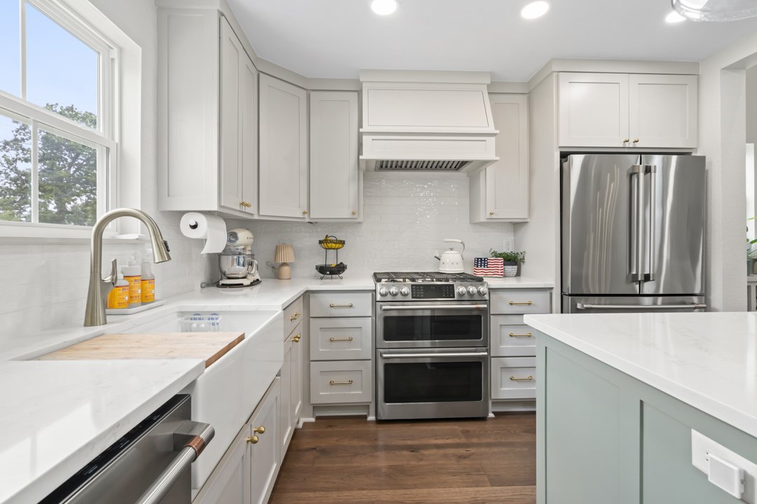 Custom kitchen featuring quartz countertops, farmhouse sink, custom cabinetry, and premium appliances in a Northwest Arkansas custom home.
