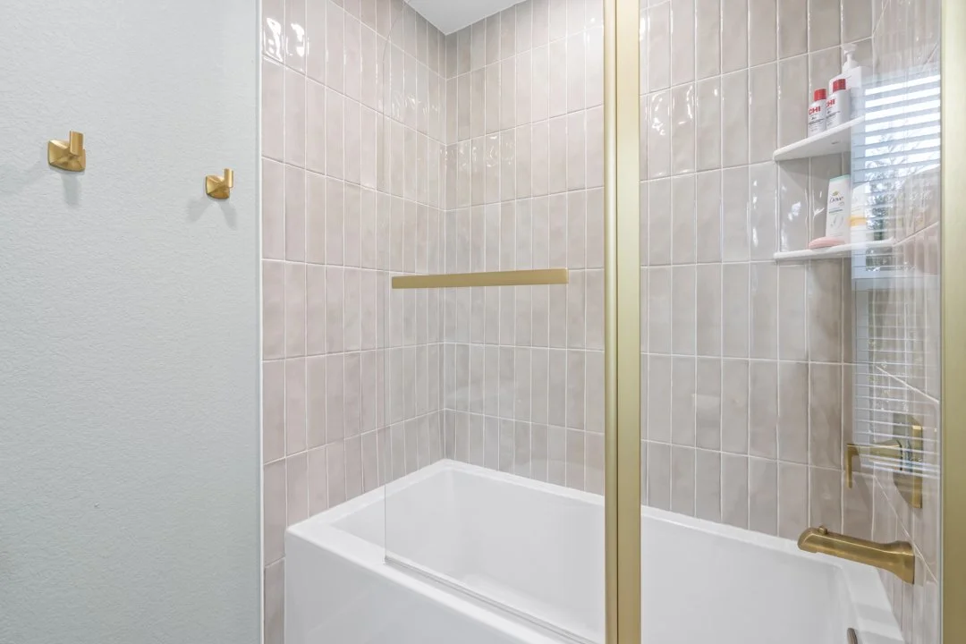 Custom tile shower with brushed gold fixtures and elegant design details in a luxury custom home in Siloam Springs.