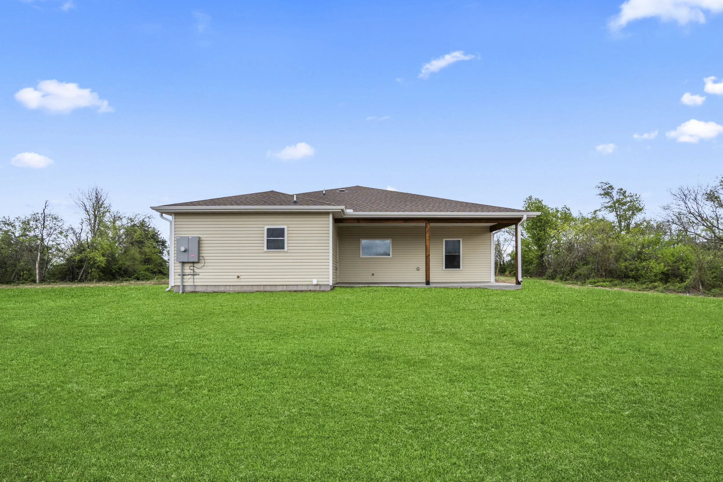 Modern custom home exterior with large backyard and outdoor living space