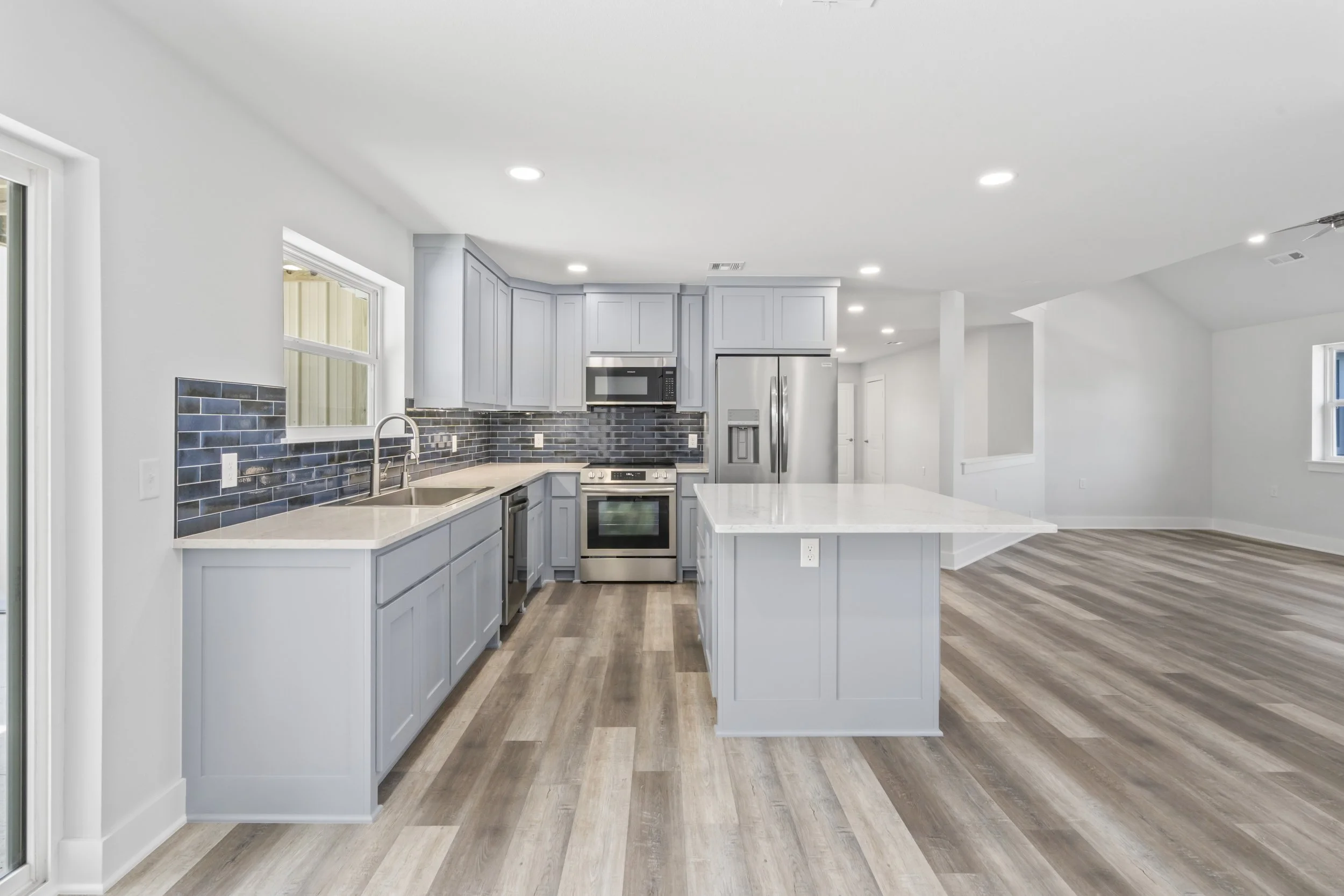 Custom kitchen interior featuring open floor plan, gray cabinets, and luxury finishes