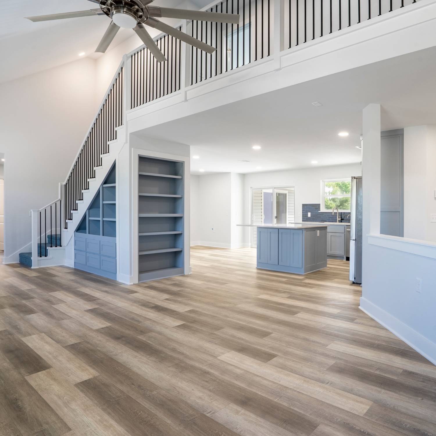 Open-concept custom home interior with staircase and kitchen built by Ahrenholtz Custom Homes in Northwest Arkansas