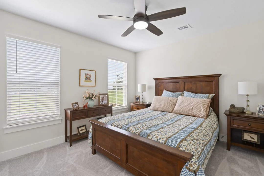 Bright and comfortable guest bedroom featuring large windows, custom trim work, and quality craftsmanship in a Siloam Springs custom home.