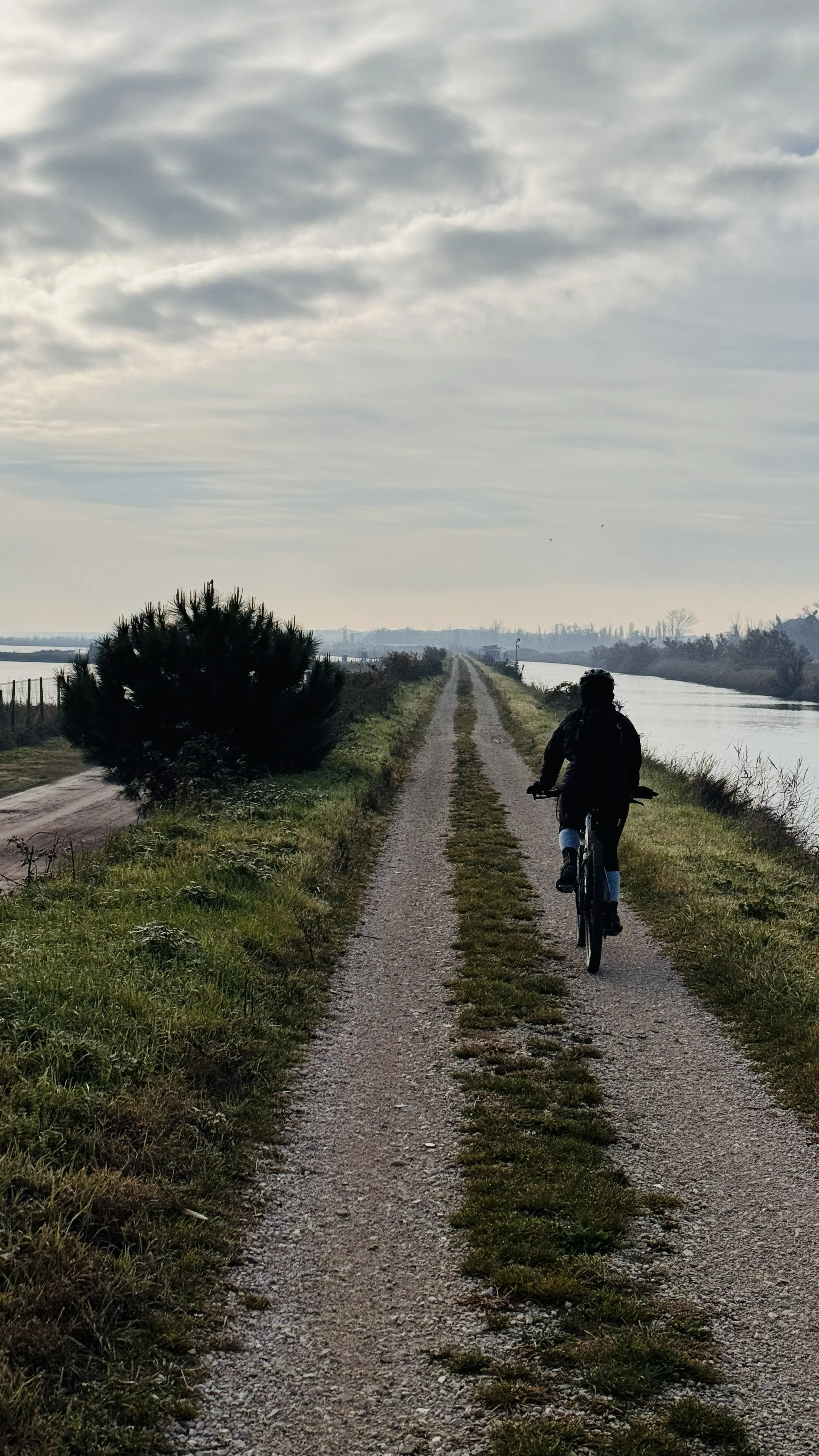 Comacchio - cyclist gravel road along the Canals