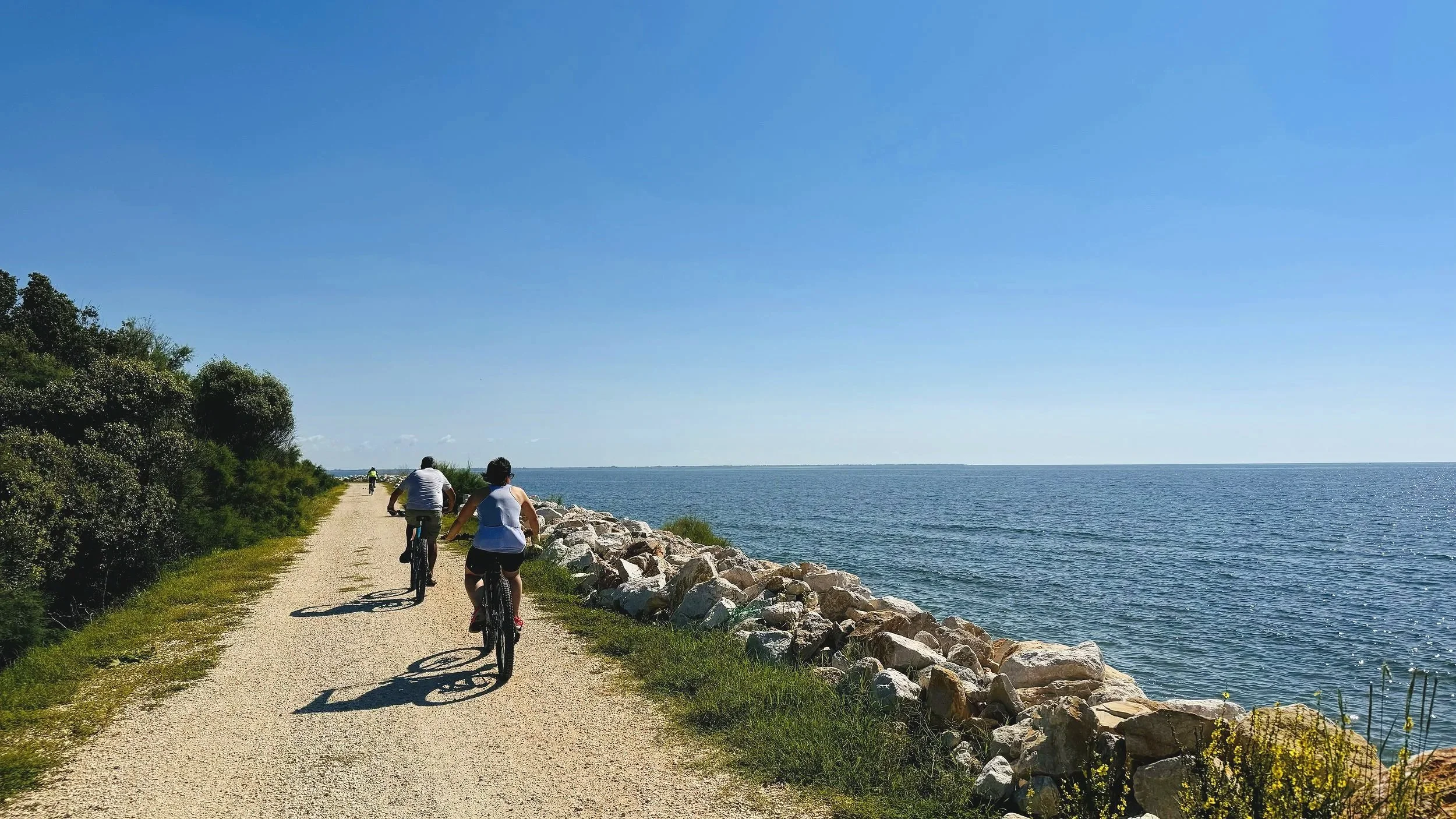 Cyclists Comacchio Coastal Gravel Road next to Porto Garibaldi