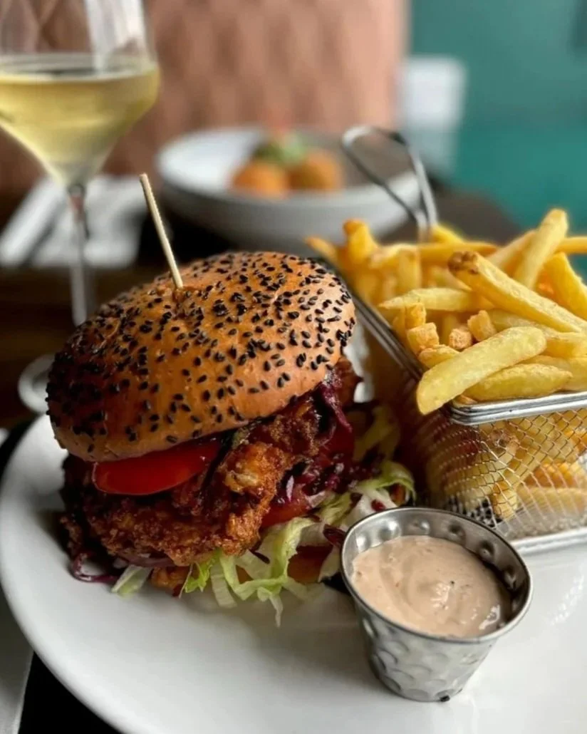 Chicken buttermilk burger Hot honey butter sauce , Asian slaw, gherkins, iceberg lettuce, beef tomato, red onion on a toasted brioche bun served with fries and chipotle mayo