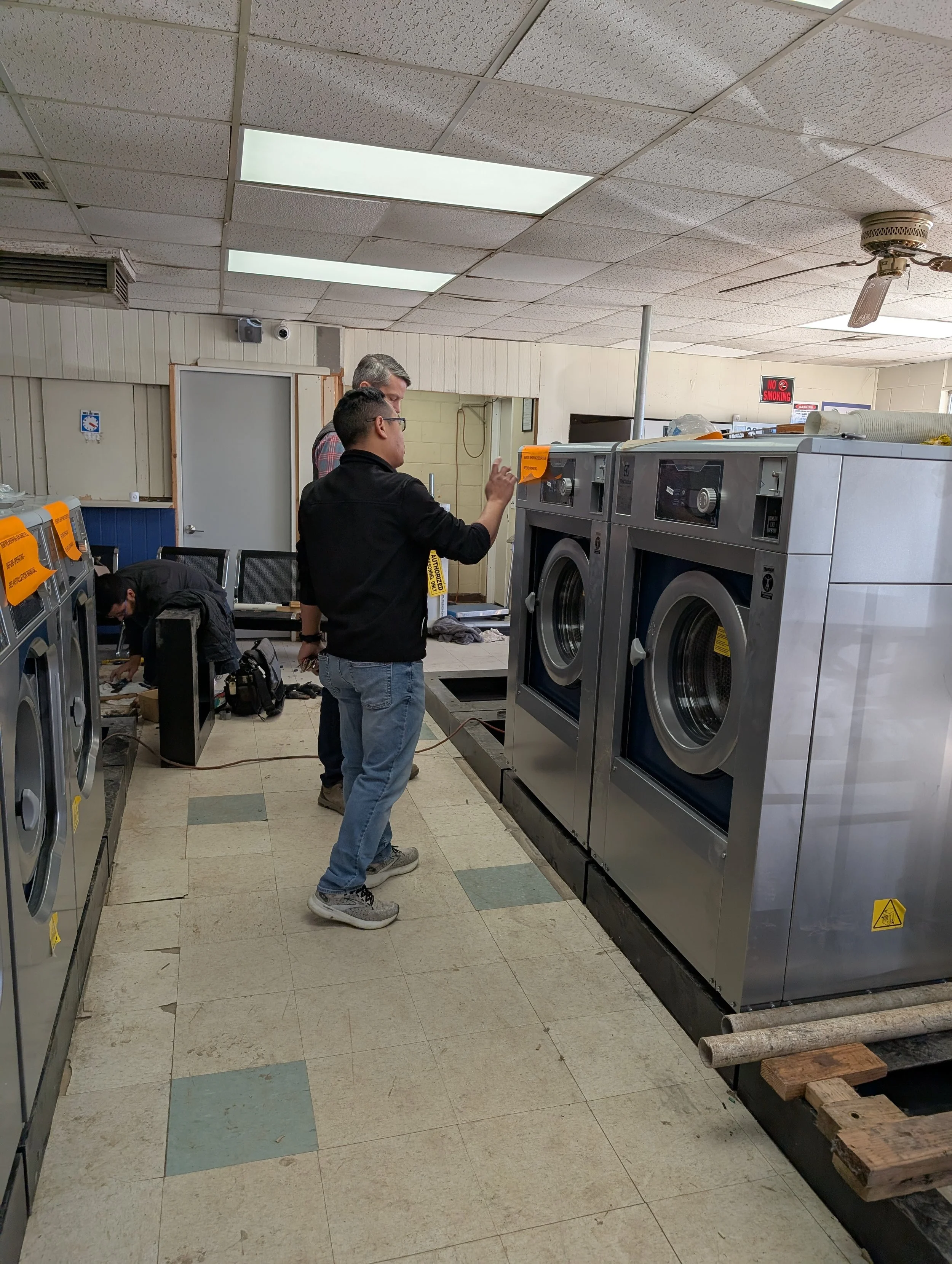 Oklahoma City laundromat remodel with commercial washers and dryers inspected by owner and Arrow Machinery team