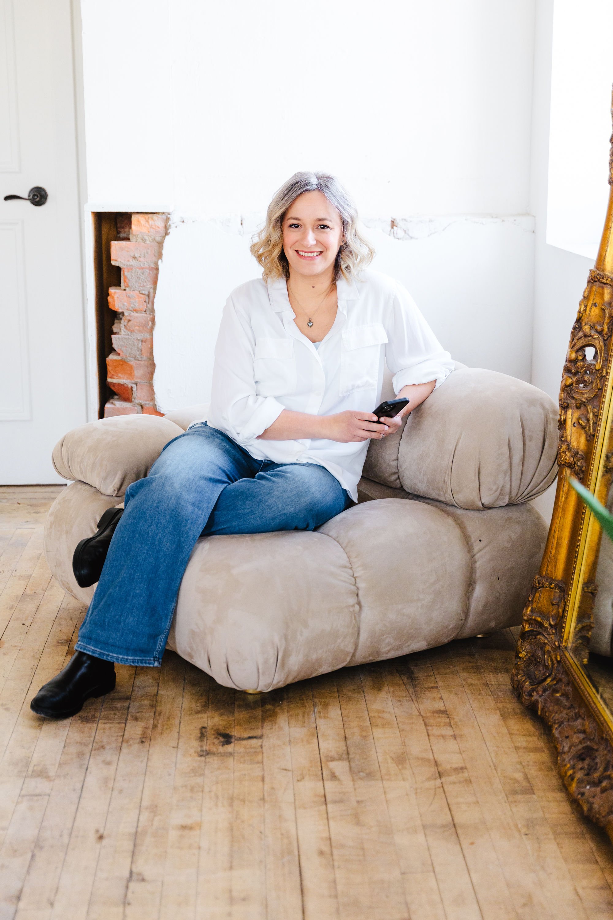 Professional organizer in Burlington, holding a cell phone and waiting for you to contact them.