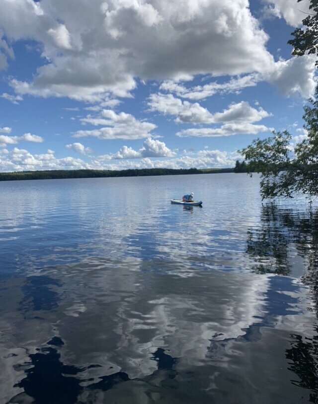 Jane on paddle board taking photos of water distant shot.jpeg