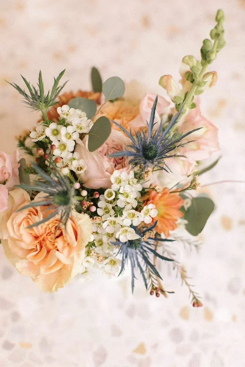 Fresh flower bouquet with peach roses, thistle and eucalyptus