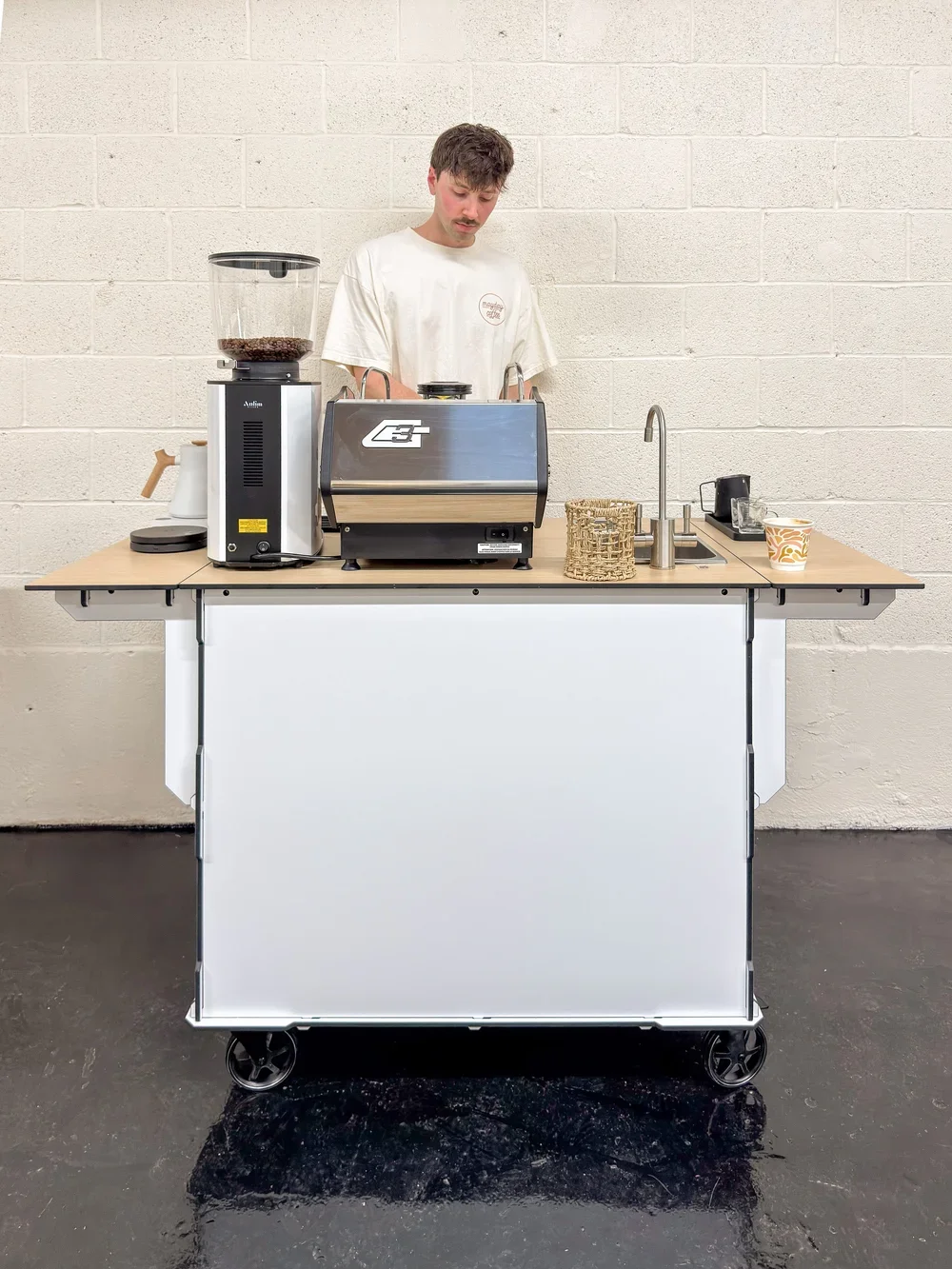 Barista preparing espresso on a mobile coffee cart with professional grinder