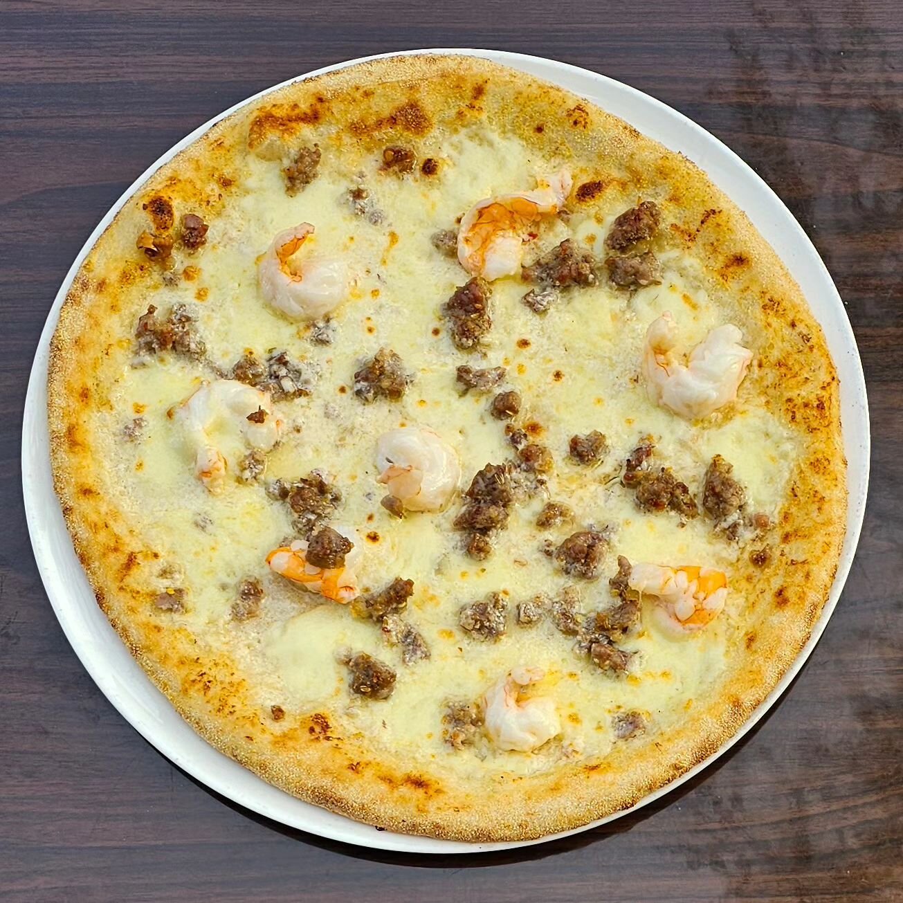 Lunch starts at 11 am. 

The return of the ever popular Mari e Monti pizza.
Mari e Monti, Italian for sea and mountain, is a pizza featuring gulf shrimp, our pork sausage, a white base, and mozzarella cheese. This is all served on our imported house