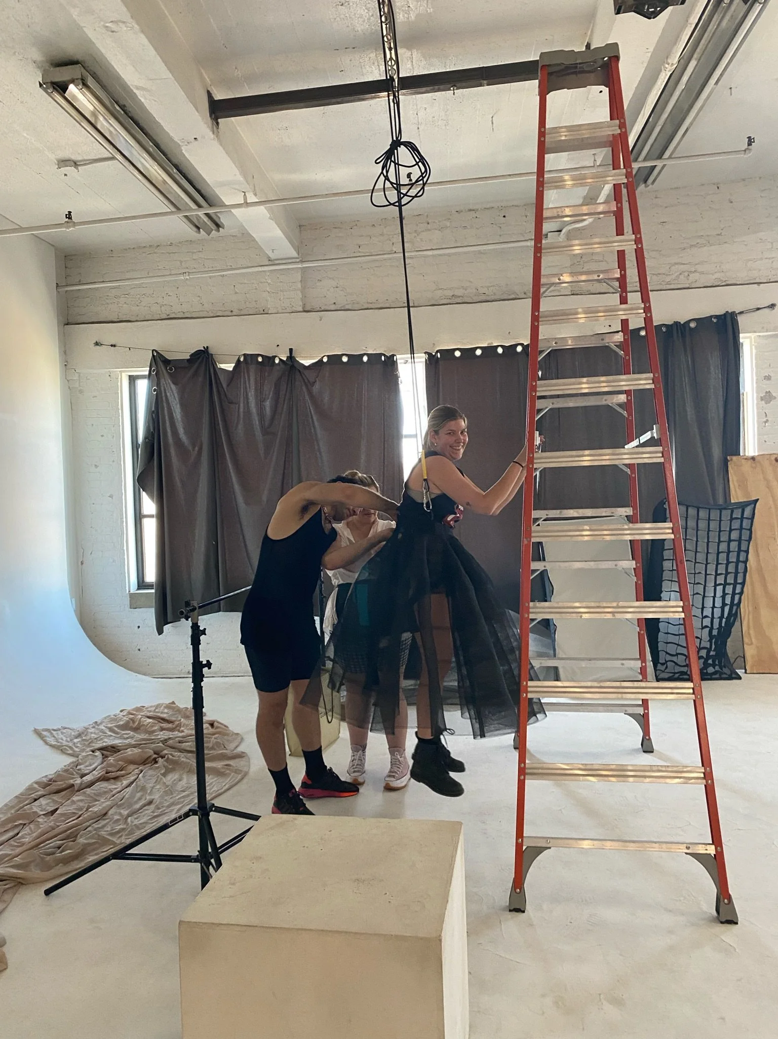 We had to figure out a way to use a rock climbing harness to rig Symone to the metal ceiling grids the perfect height in front of the draping. 