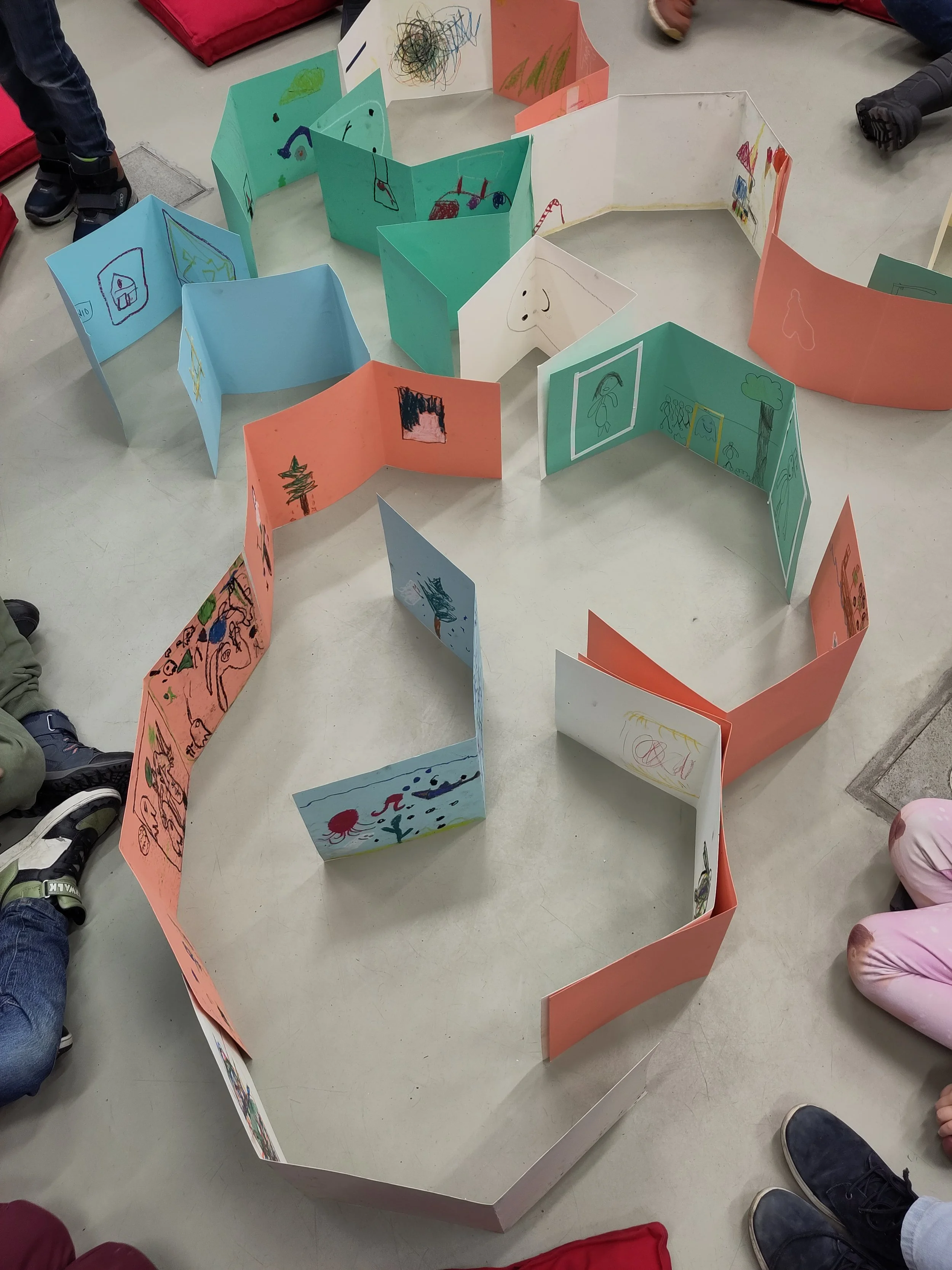 Eine Landschaft aus gefalteten bunten Pappen mit Kinderzeichnungen aus einem Museumsbesuch darauf.