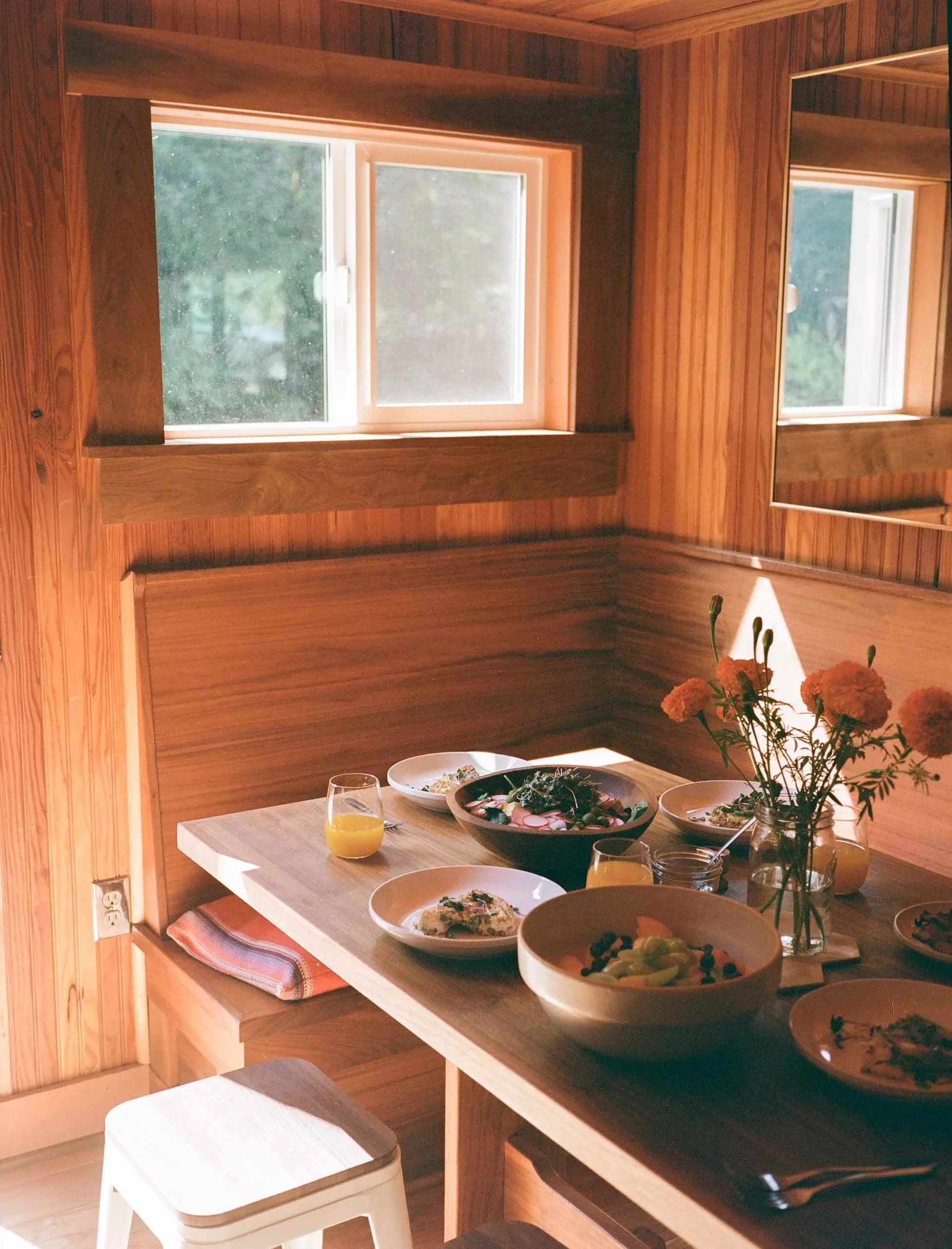 Rustic dining table inside the Sweet Root Hollow farmhouse with refined natural textures and warm wood details.