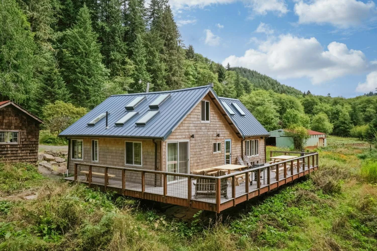 Rustic farmhouse in Cloverdale, Oregon with spacious deck, picnic tables, and chairs