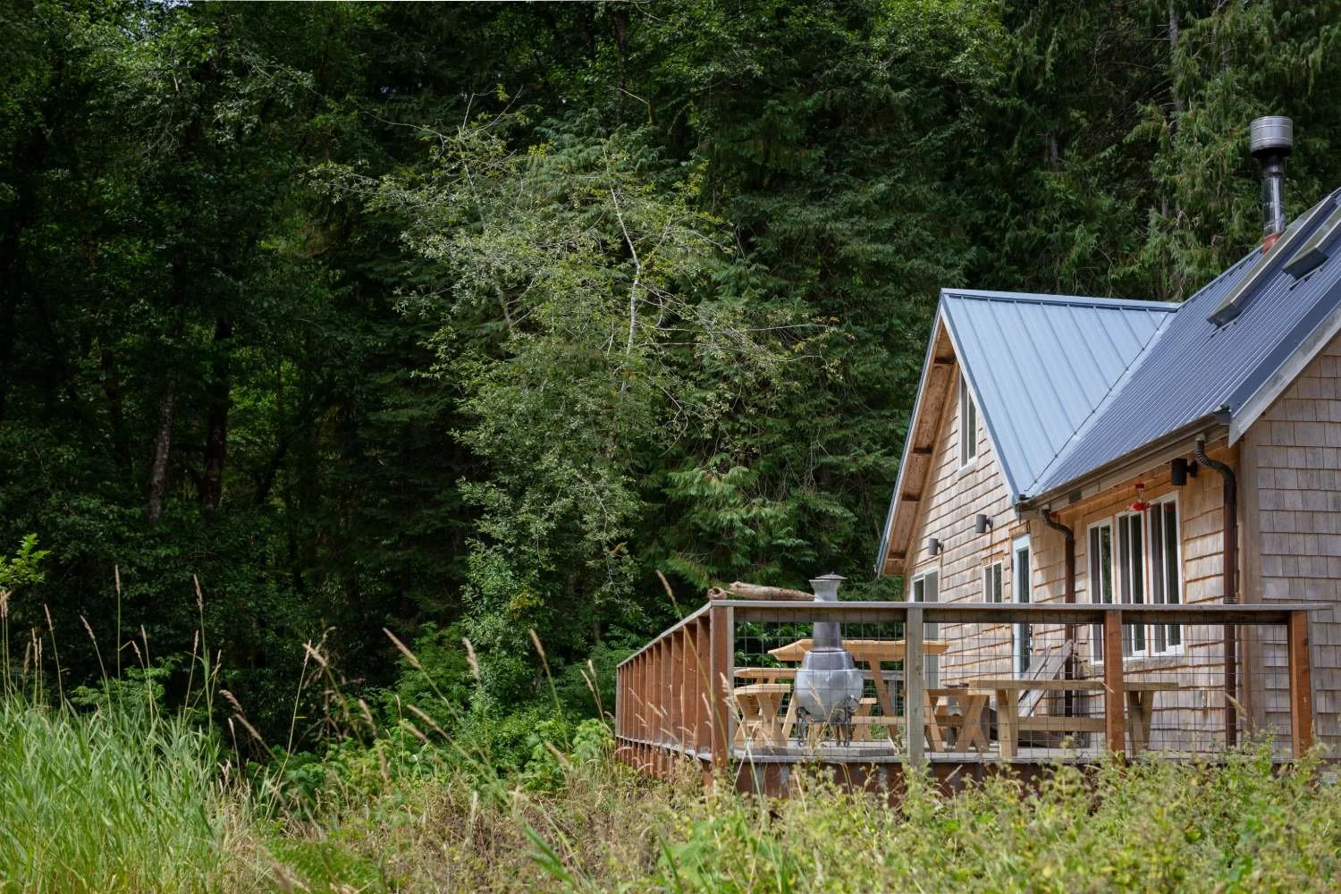 Rustic farmhouse in Cloverdale, Oregon with spacious deck, picnic tables, and chairs
