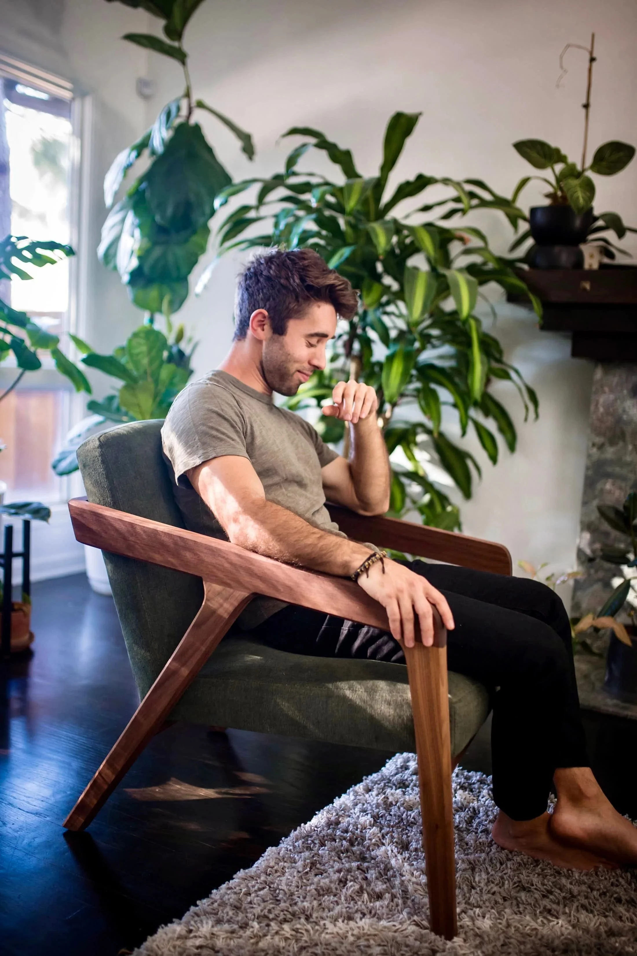 Farmer Nick sits in a sustainable chair with many plants in the background