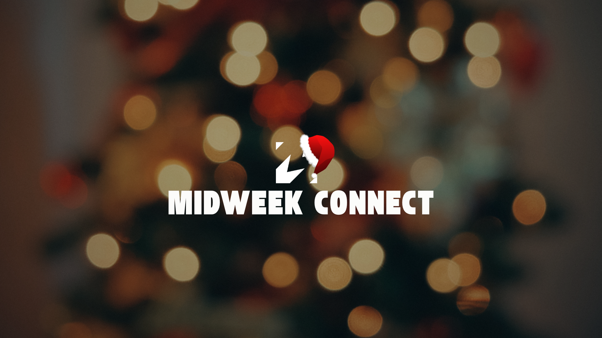 A group of people attending a classroom seminar or workshop with a presenter at the front, a large screen, and colorful posters on the wall.